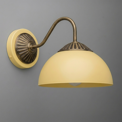 Wall sconce with curved antique brass arm and round beige glass shade mounted on decorative brass backplate. - SCONCE MODEL NO. 9408