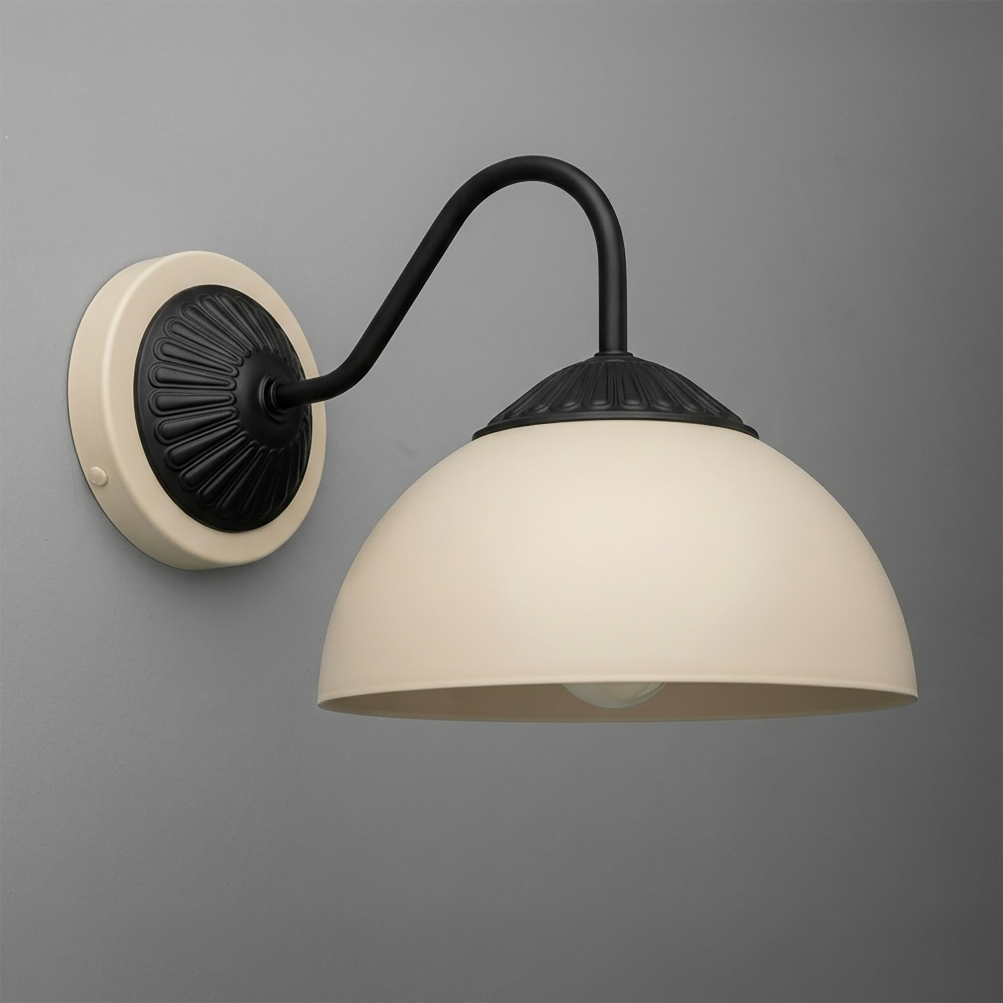 Black metal wall sconce with curved arm and matte cream dome shade mounting on round beige base. - SCONCE MODEL NO. 9408