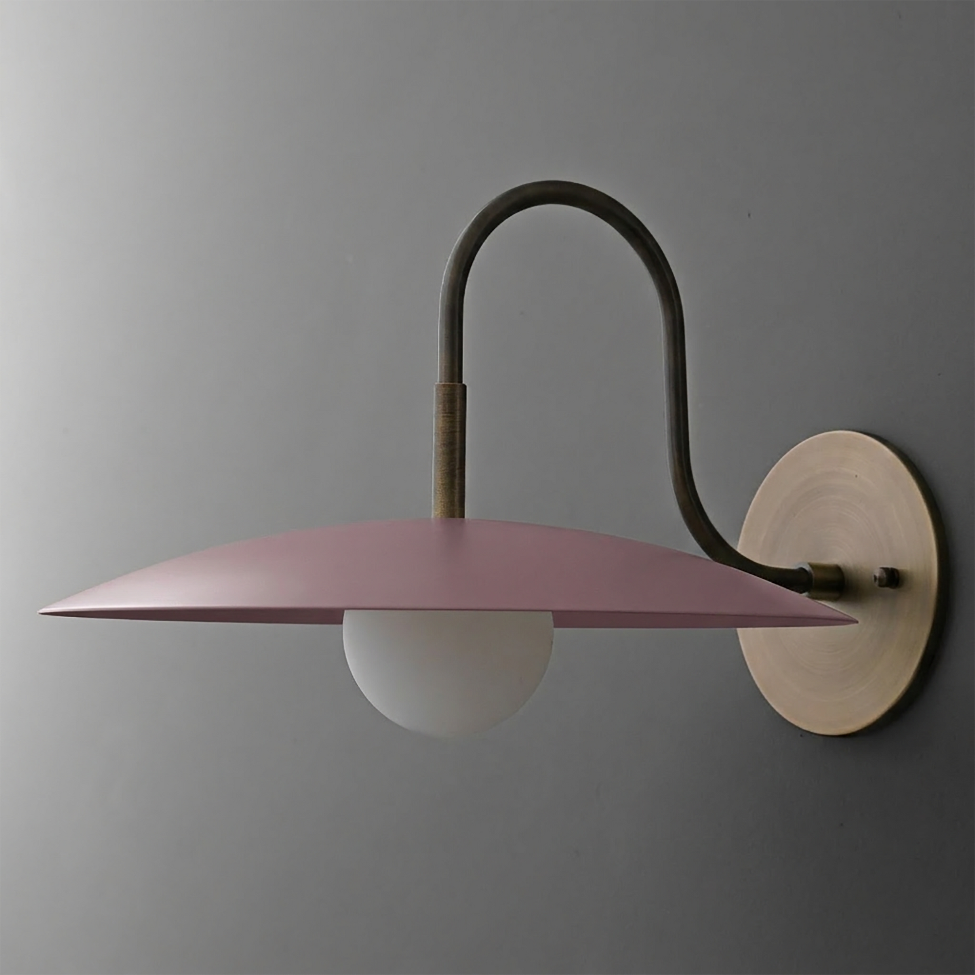 Matte pink disc-shaped metal shade sconce with frosted globe bulb and antique brass wall mount. - SCONCE MODEL NO. 9171