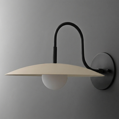 Black metal wall sconce with curved arm and flat beige shade over a white globe bulb. - SCONCE MODEL NO. 9171