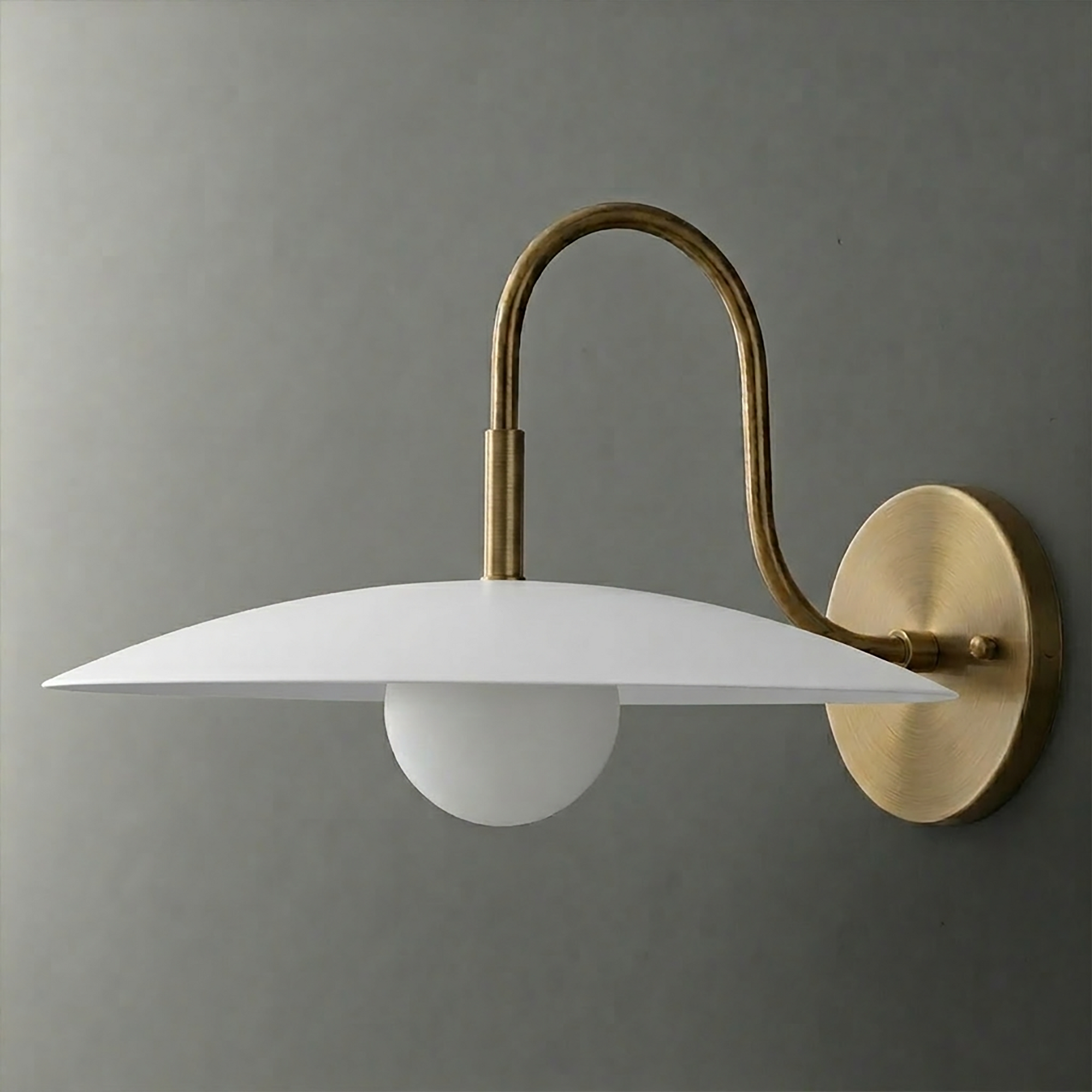 Wall sconce with brushed brass arm and round backplate, white disc-shaped shade, and globe bulb. - SCONCE MODEL NO. 9171