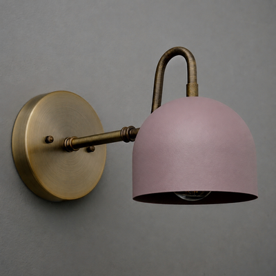 Wall-mounted sconce with aged brass arm and round base, featuring a matte pink domed metal shade. - SCONCE MODEL NO. 3628