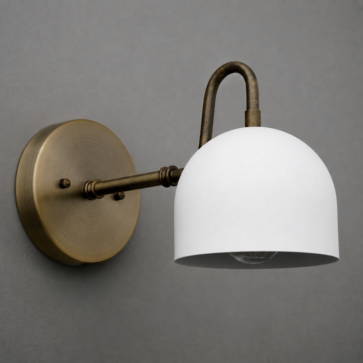 Wall sconce with antique brass finish, curved arm, and matte white dome-shaped glass shade. - SCONCE MODEL NO. 3628