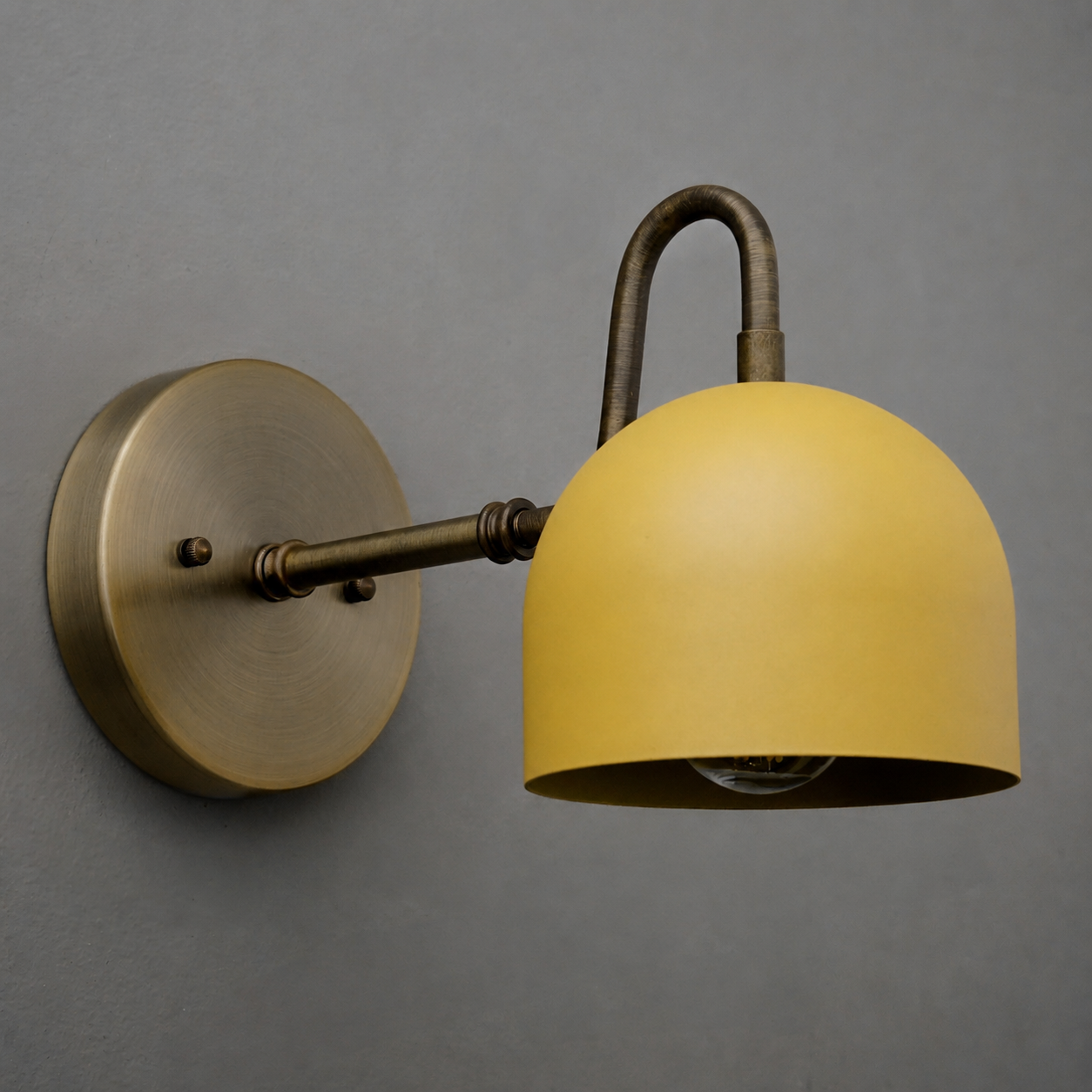 Wall-mounted sconce with aged brass finish and a smooth yellow dome-shaped metal shade. - SCONCE MODEL NO. 3628