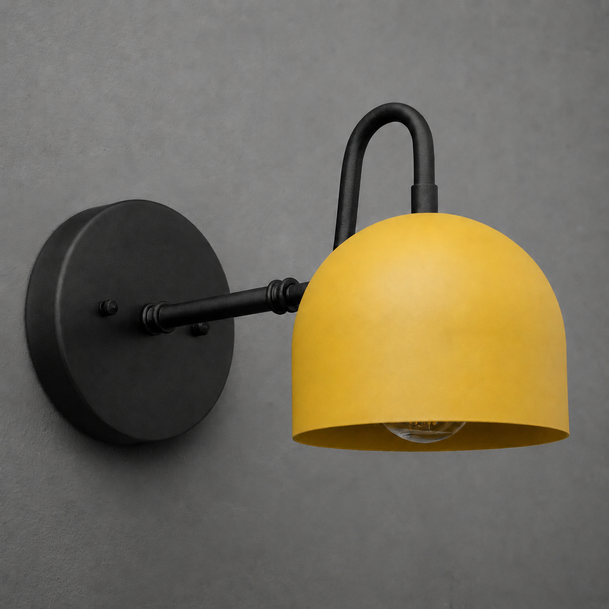 Black metal wall sconce with curved arm and matte yellow dome-shaped shade, exposed bulb inside. - SCONCE MODEL NO. 3628