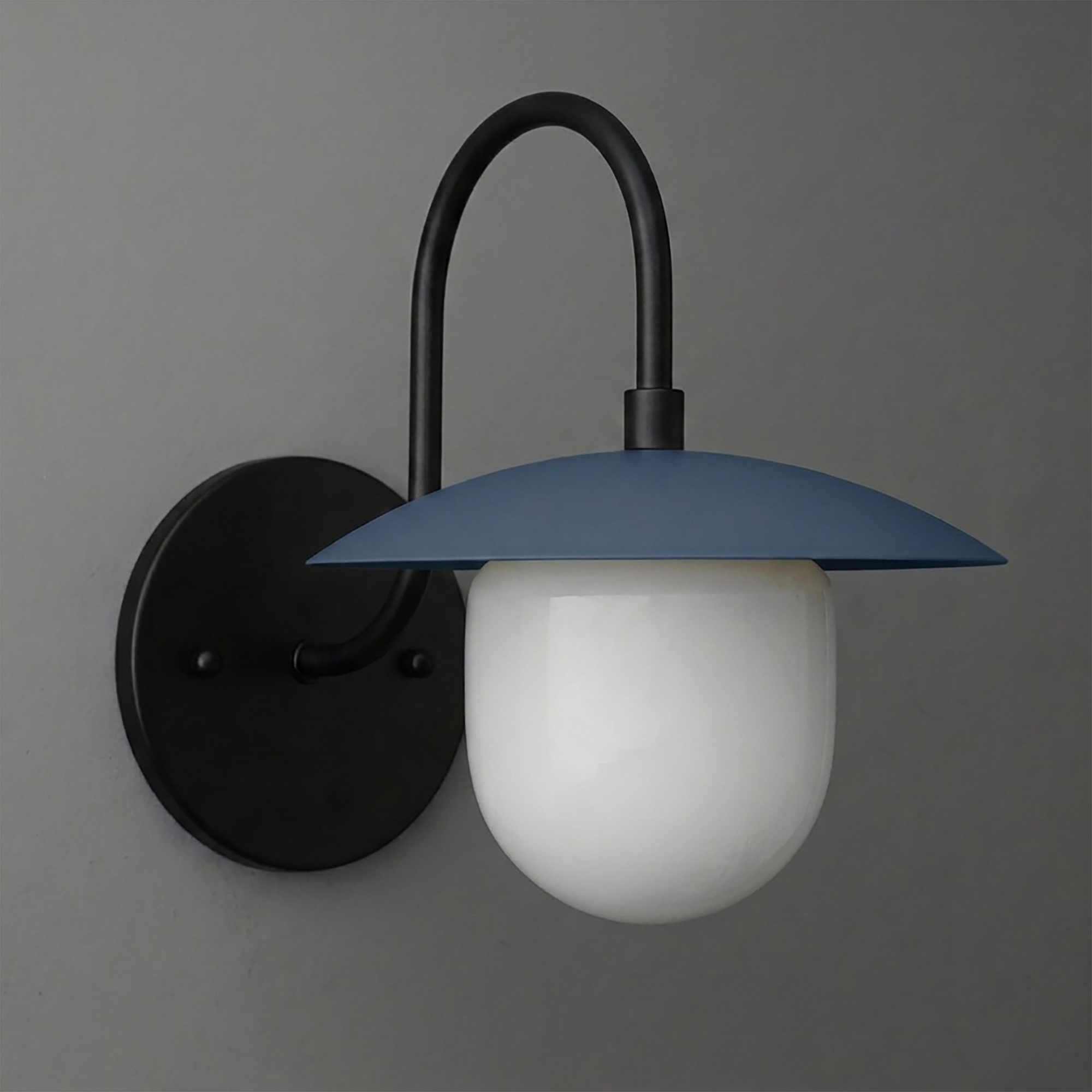 Wall sconce with matte black metal arm and round backplate, featuring a blue curved shade and frosted white glass bulb cover. - SCONCE MODEL NO. 7191