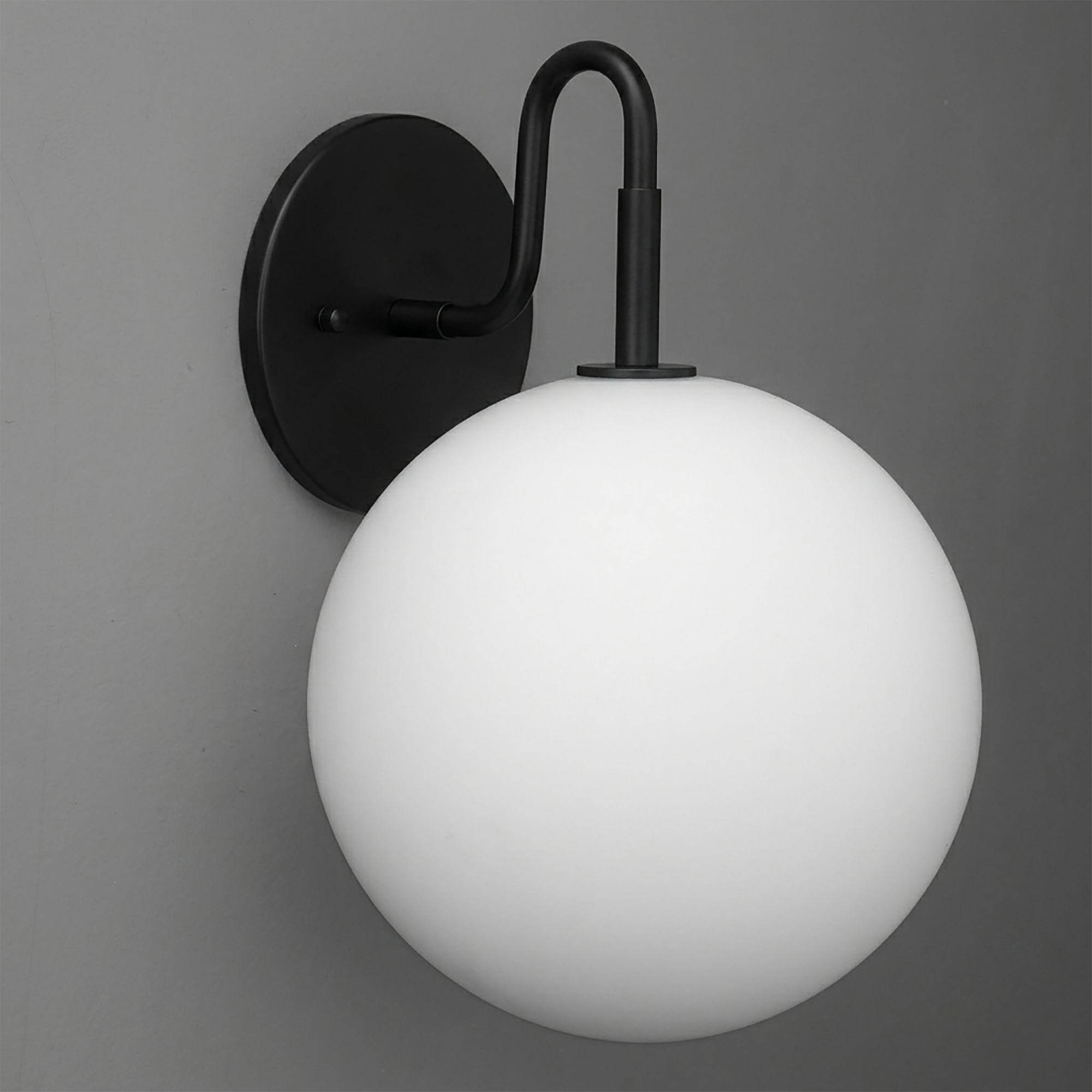 Matte black metal wall sconce with a smooth white frosted glass globe shade and curved arm. - SCONCE MODEL NO. 0478