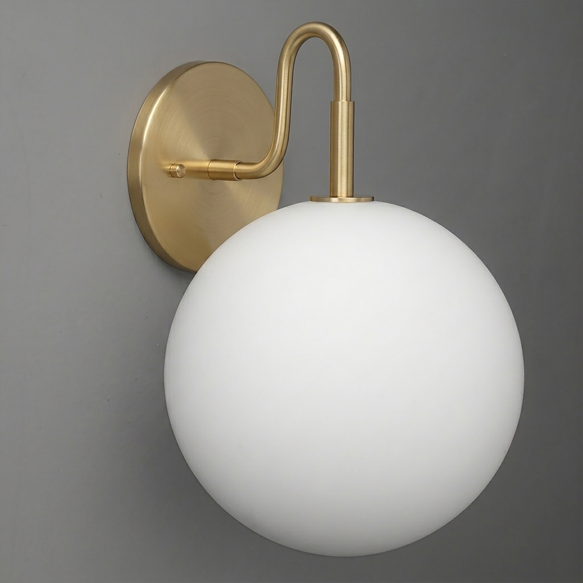 Wall sconce with a round white frosted glass globe and brushed brass arm and mount. - SCONCE MODEL NO. 0478