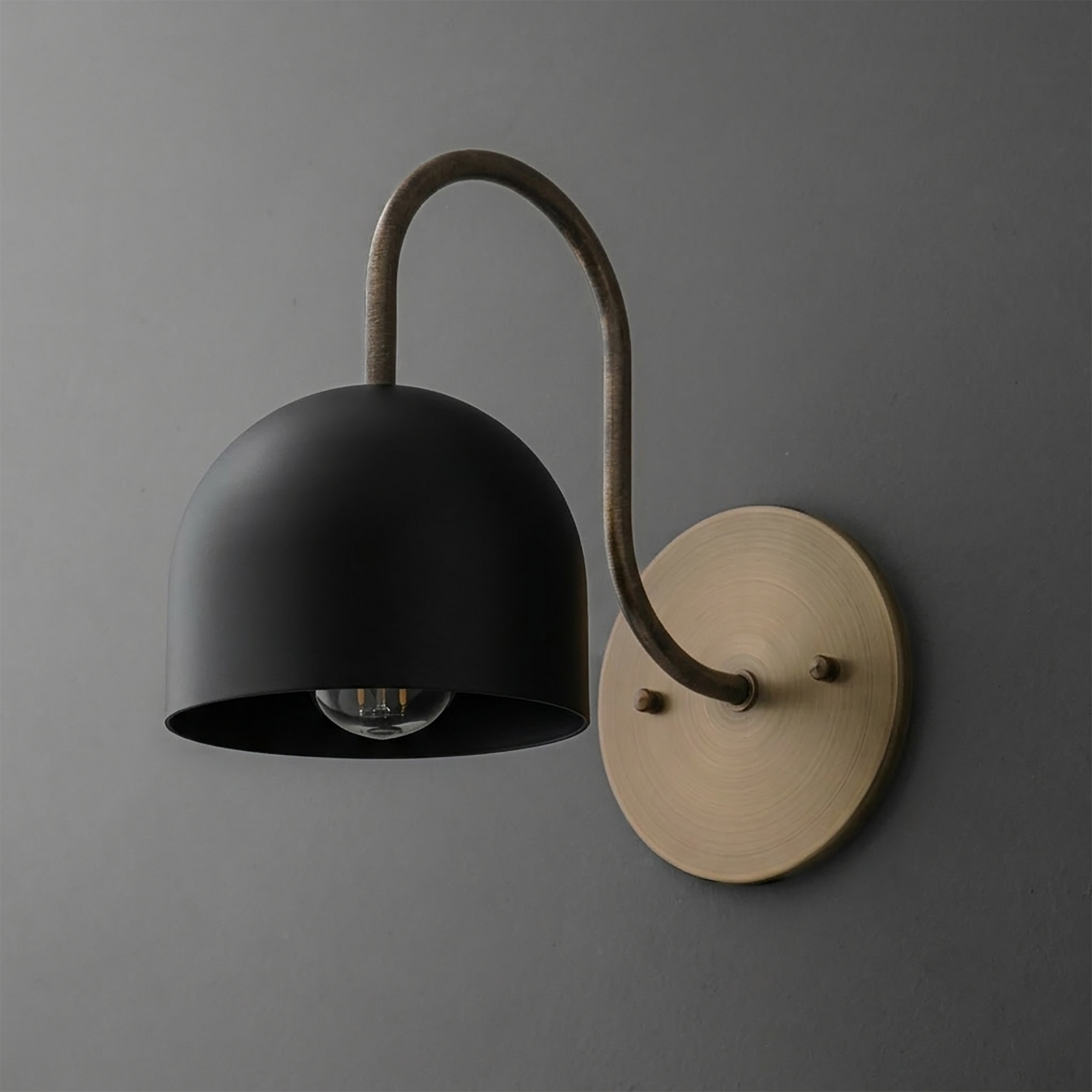 Matte black dome-shaped metal sconce with curved bronze arm and round brass wall mount. - SCONCE MODEL NO. 6308