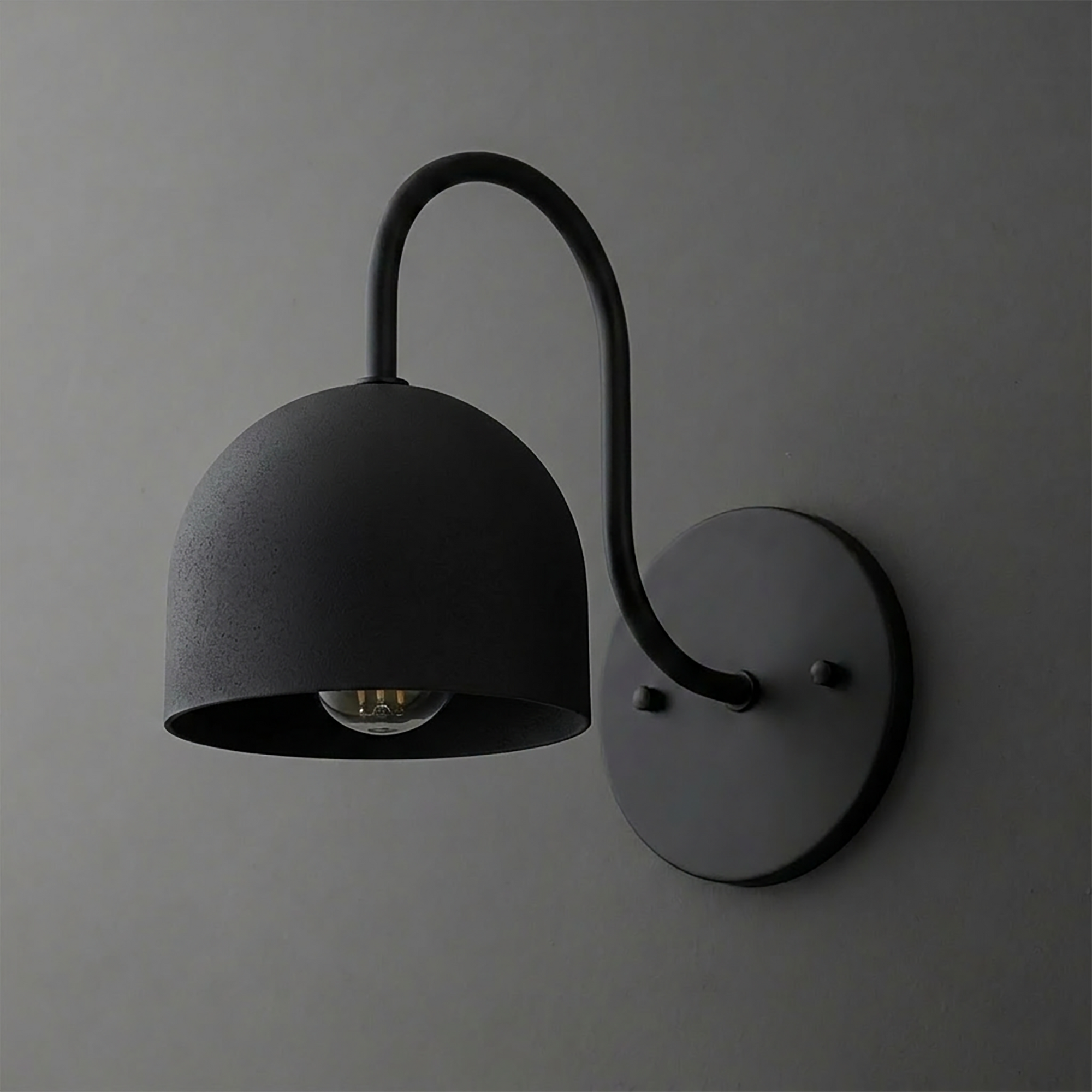 Matte black metal wall sconce with a curved arm and deep dome-shaped shade covering one bulb. - SCONCE MODEL NO. 6308