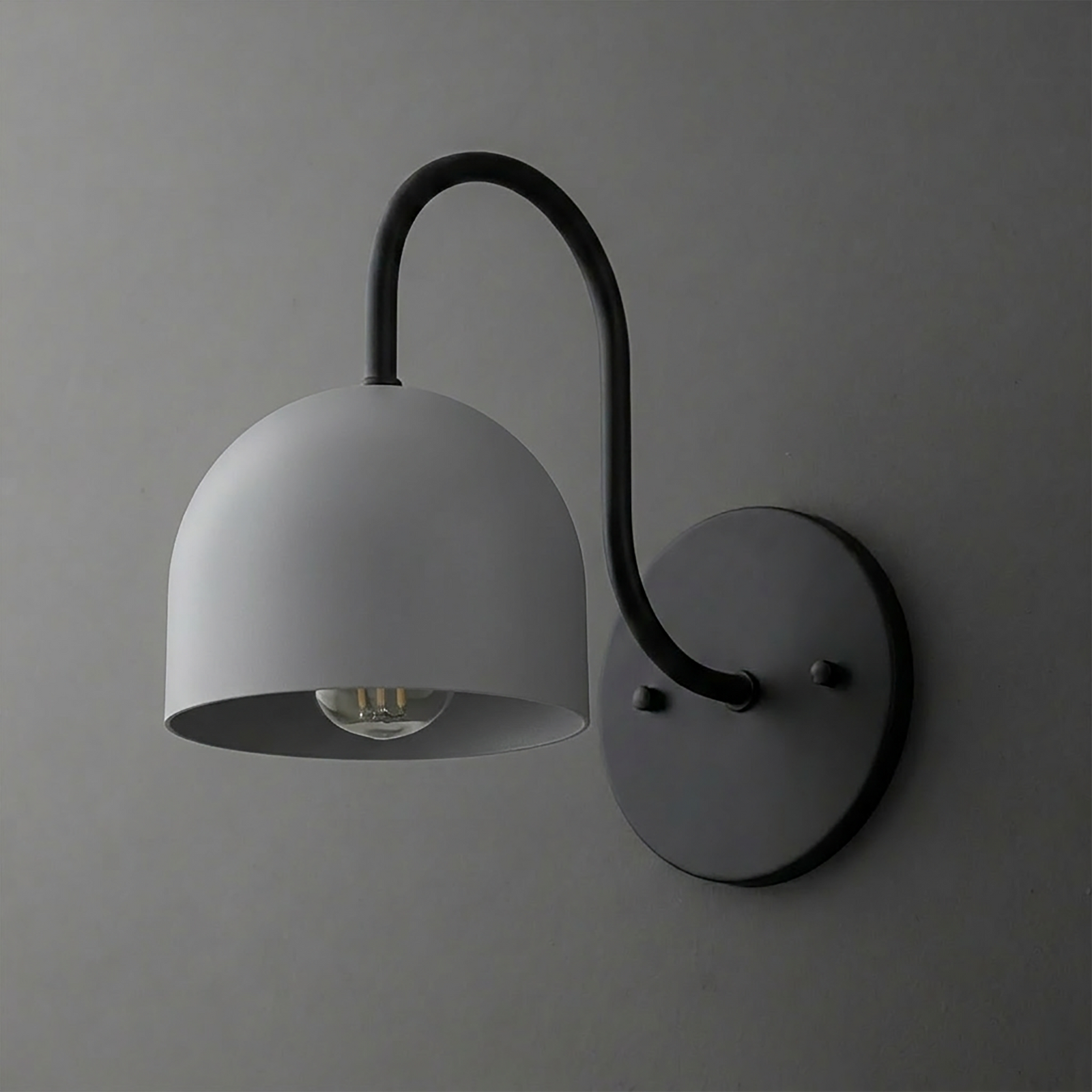 Matte black metal wall sconce with curved arm and dome-shaped shade over exposed bulb. - SCONCE MODEL NO. 6308