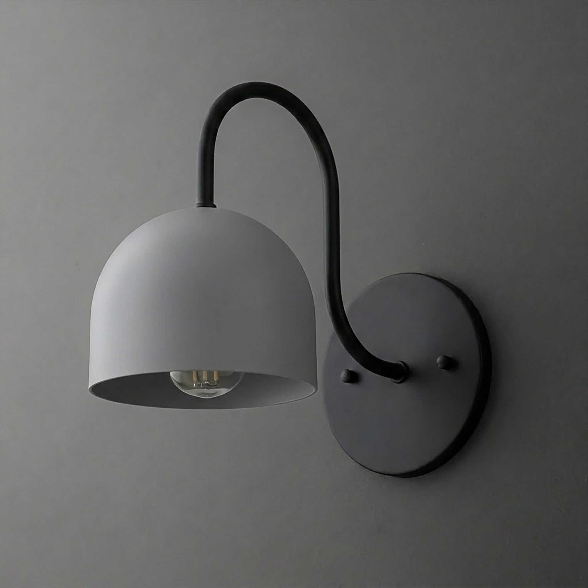 Matte black metal wall sconce with curved arm and dome-shaped shade over exposed bulb. - SCONCE MODEL NO. 6308