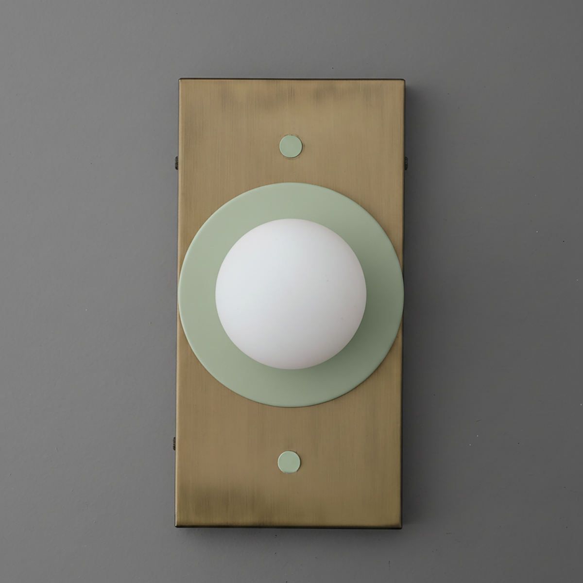 Wall sconce with antique brass rectangular backplate and cream green circular accent holding a white globe bulb. - SCONCE MODEL NO. 4474