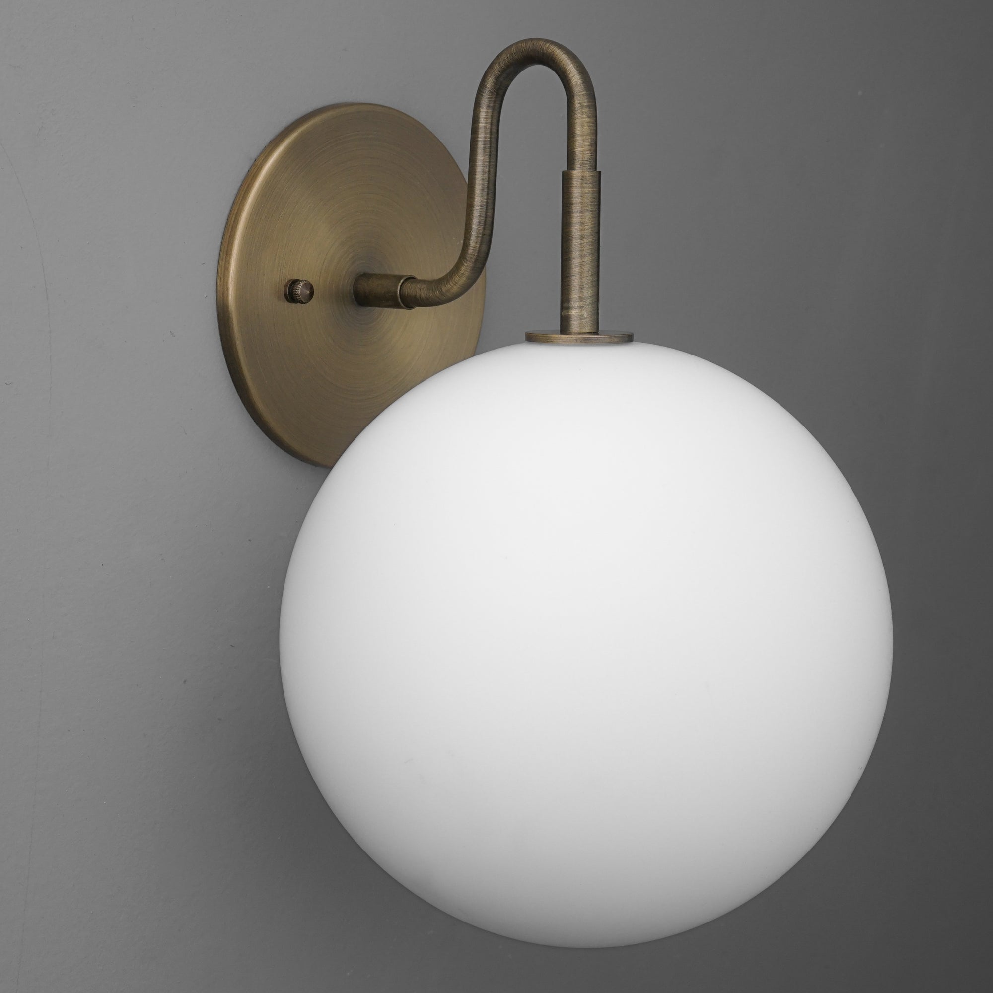 Wall sconce with antique brass finish and large frosted white glass globe shade. - SCONCE MODEL NO. 0478