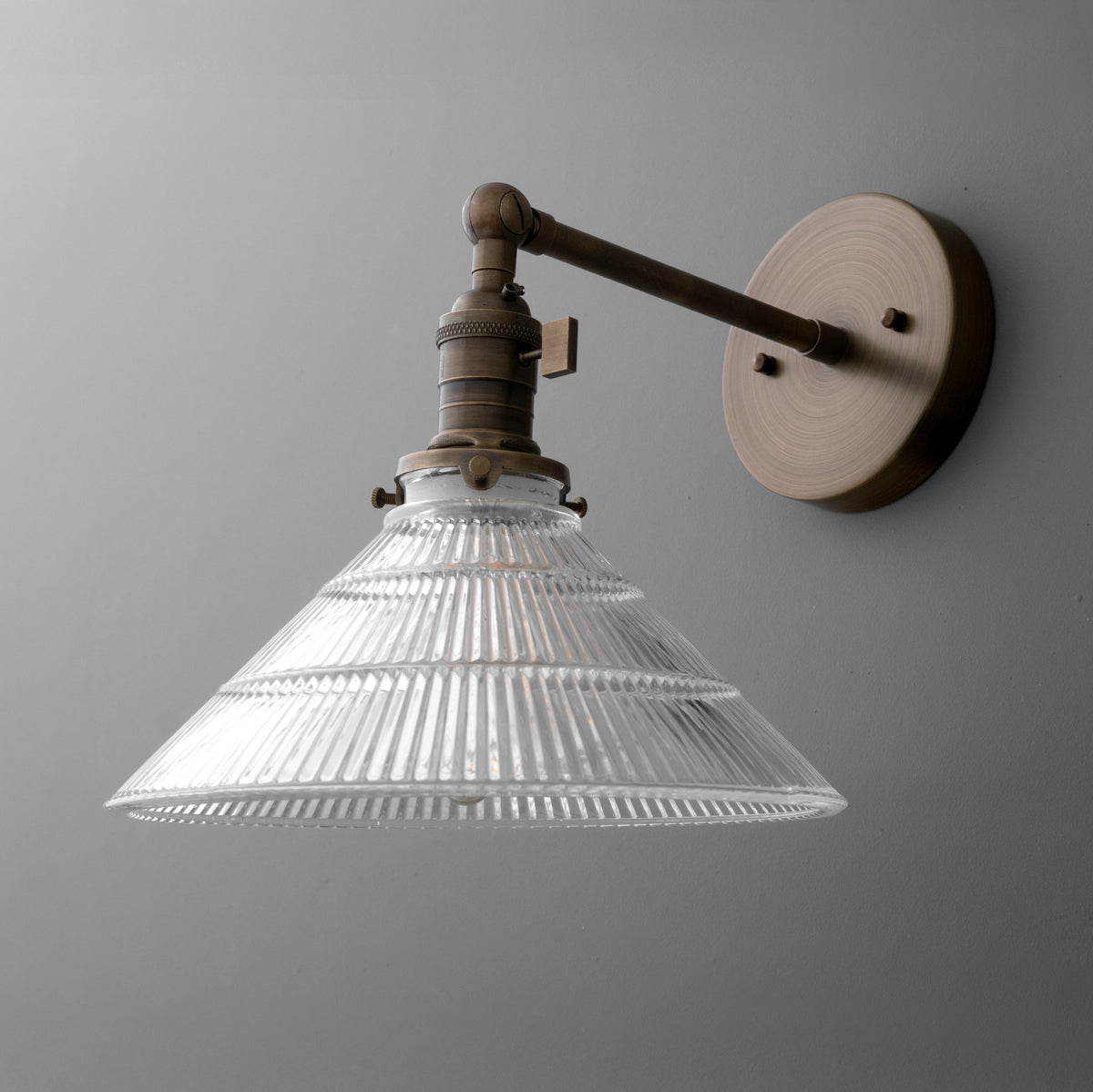 Wall-mounted bronze sconce with conical ribbed glass shade and single bulb fixture. - SCONCE MODEL NO. 3170