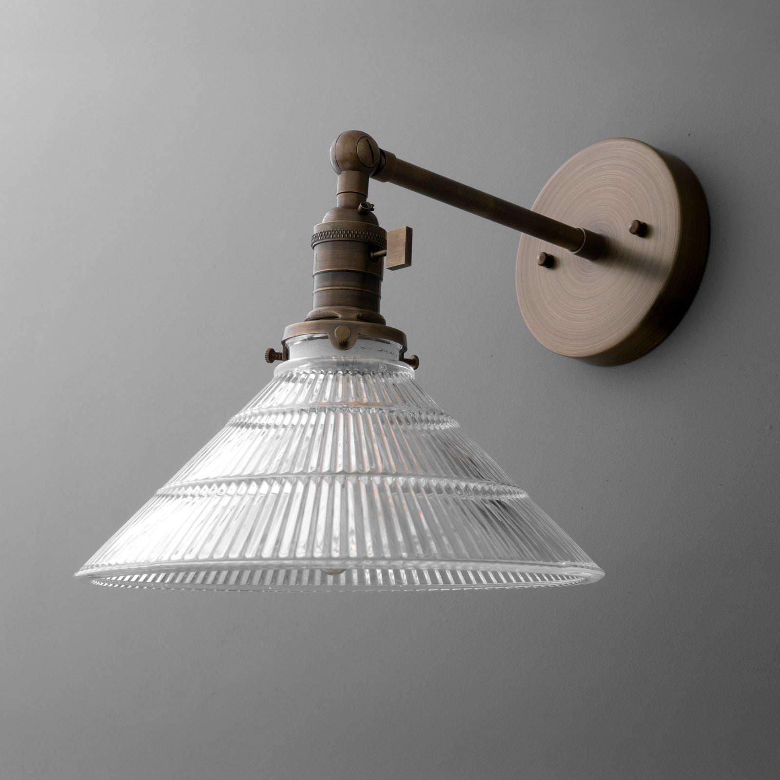 Wall-mounted bronze sconce with conical ribbed glass shade and single bulb fixture. - SCONCE MODEL NO. 3170