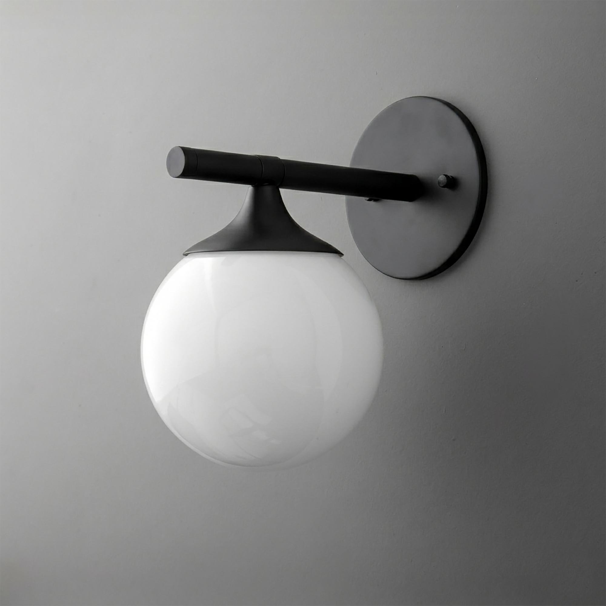Black metal wall sconce with matte finish and large white frosted glass globe shade. - SCONCE MODEL NO. 1098