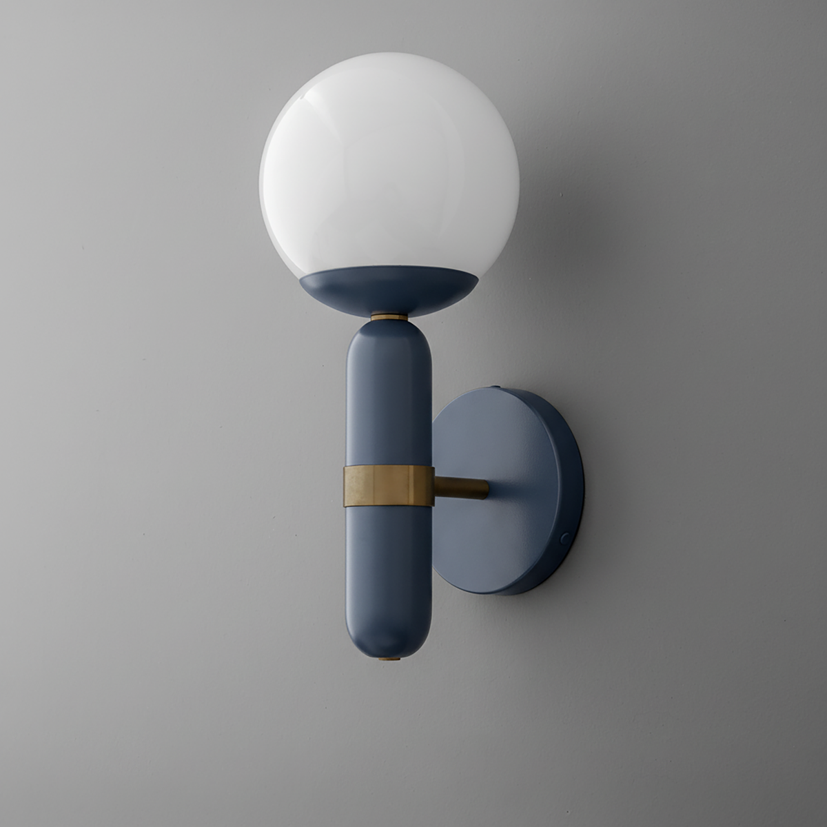 Wall sconce with round white glass shade and matte black metal base with brass accent. - SCONCE MODEL NO. 4786