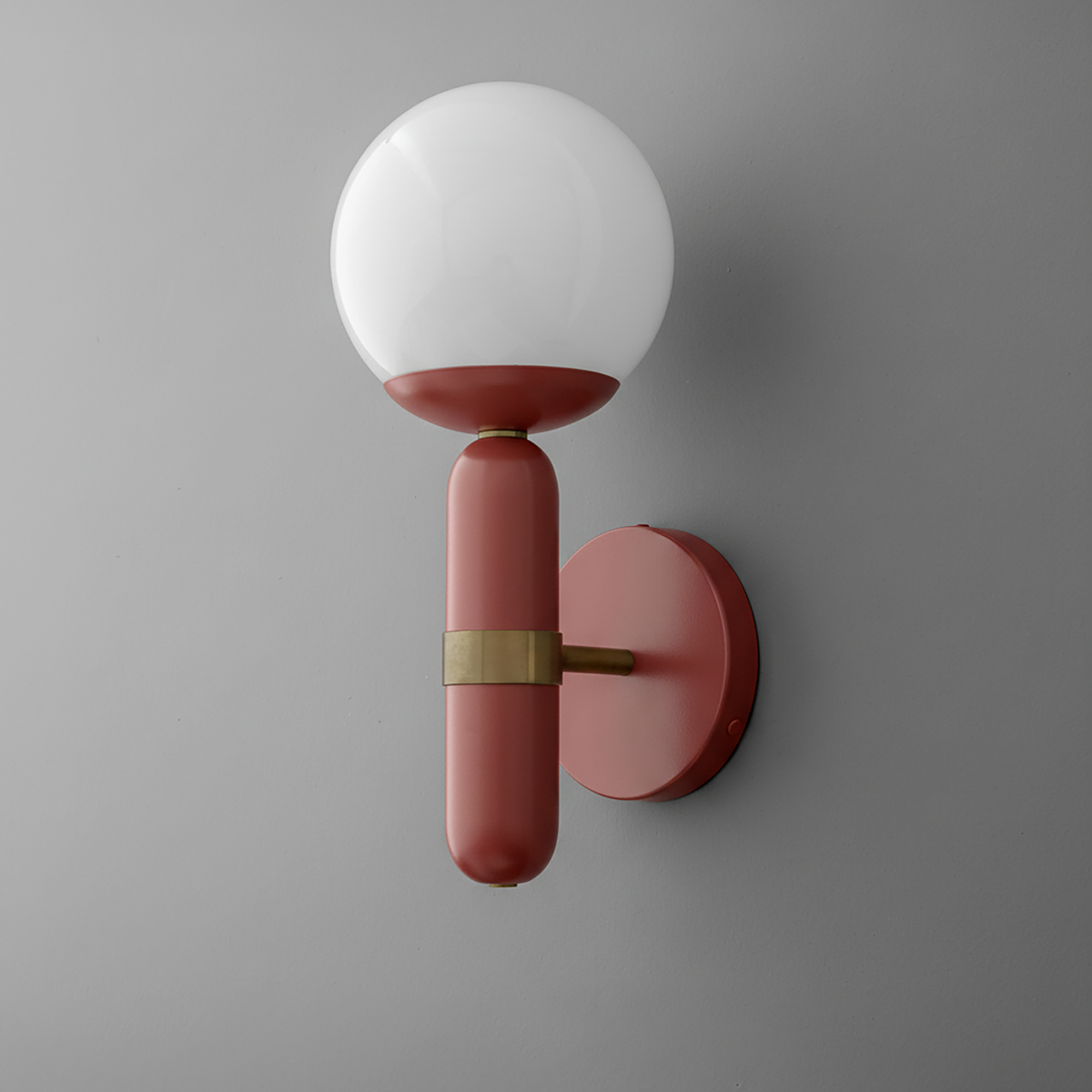 Wall sconce with round white glass shade and matte brick red brass base with horizontal brass accent. - SCONCE MODEL NO. 4786