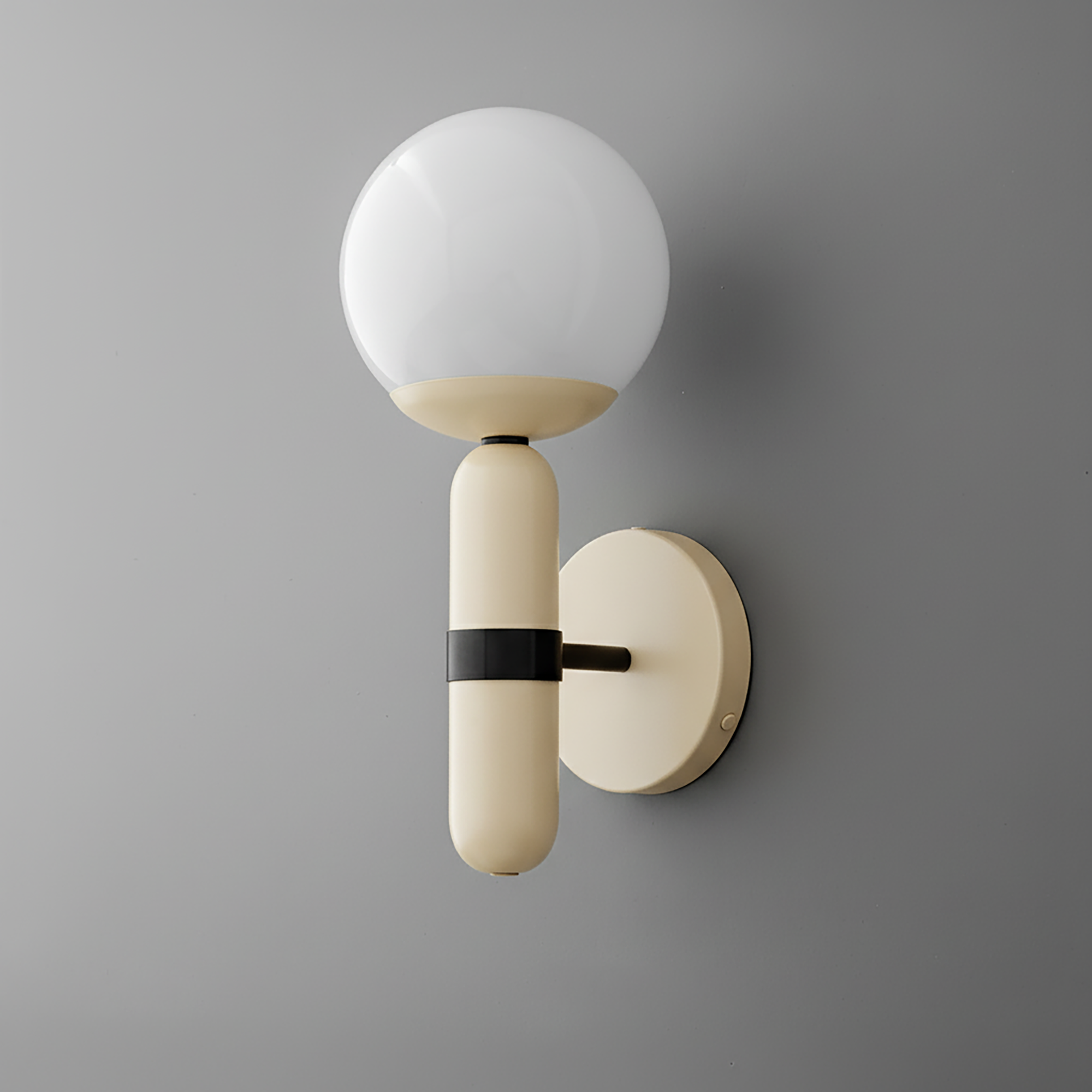 Wall sconce with round white glass shade and cream-colored metal base with black accent on gray wall. - SCONCE MODEL NO. 4786