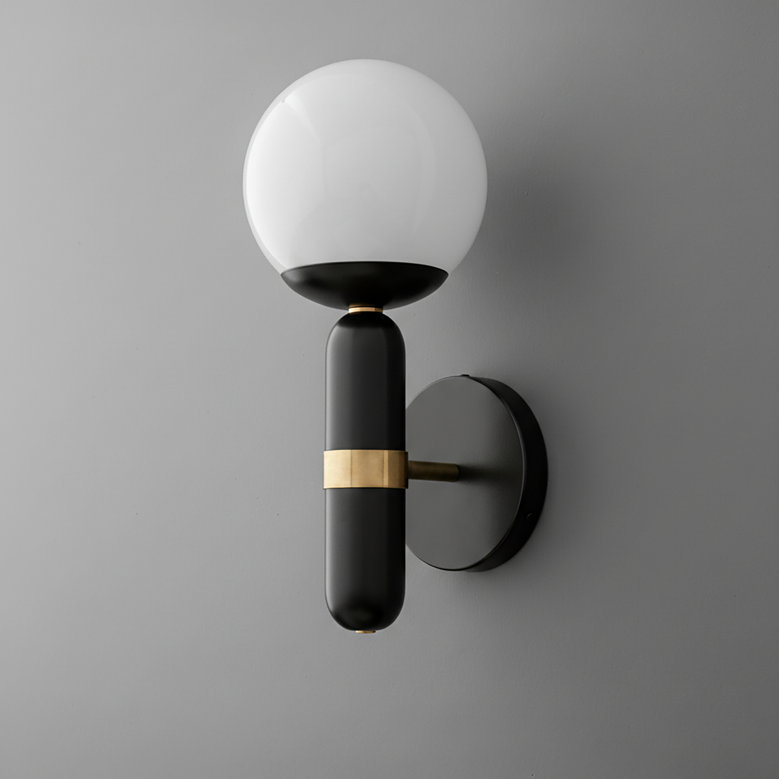 Black wall sconce with round white glass globe and horizontal brass accent on cylindrical base. - SCONCE MODEL NO. 4786
