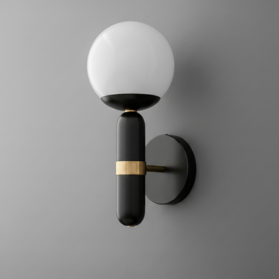 Black wall sconce with round white glass globe and horizontal brass accent on cylindrical base. - SCONCE MODEL NO. 4786