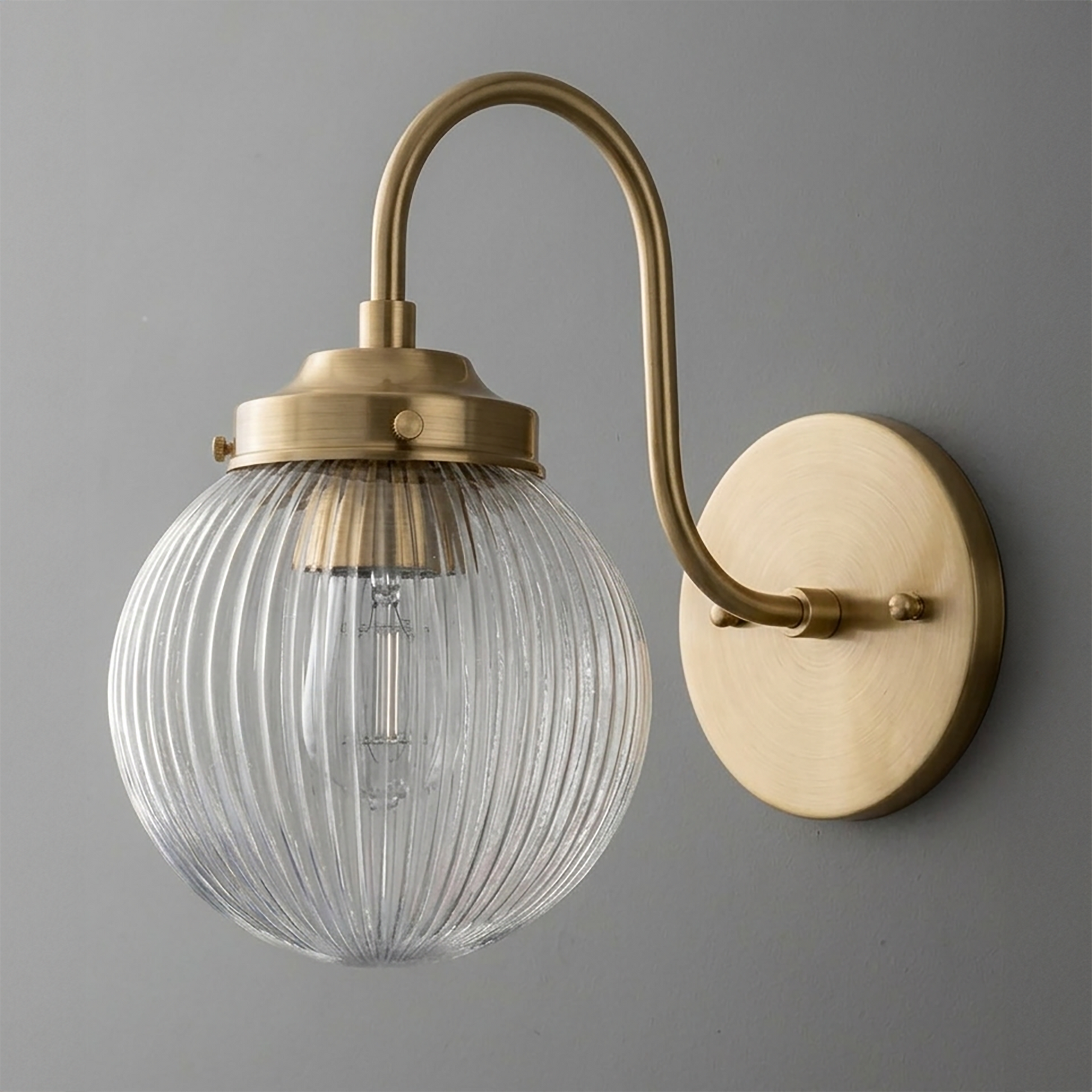Wall sconce with curved brass arm and round ribbed clear glass globe shade. - SCONCE MODEL NO. 0691