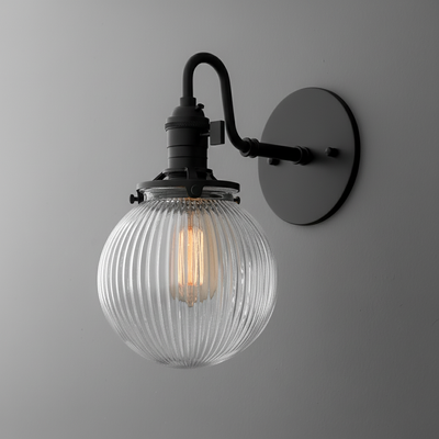 Black metal wall sconce with ribbed clear glass globe shade and vintage-style filament bulb. - SCONCE MODEL NO. 3331