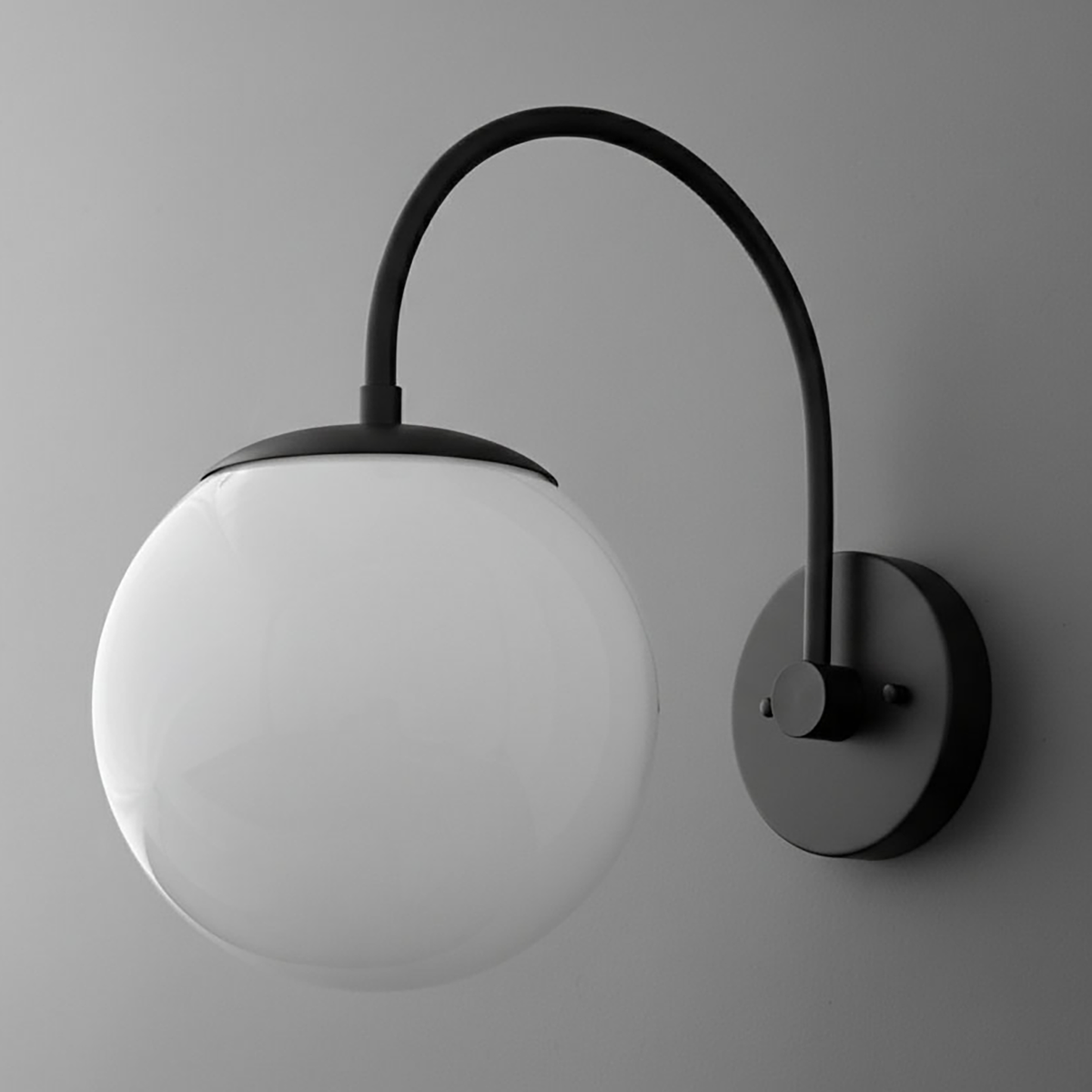 Black metal wall sconce with curved arm and large white glass globe shade. - SCONCE MODEL NO. 2947