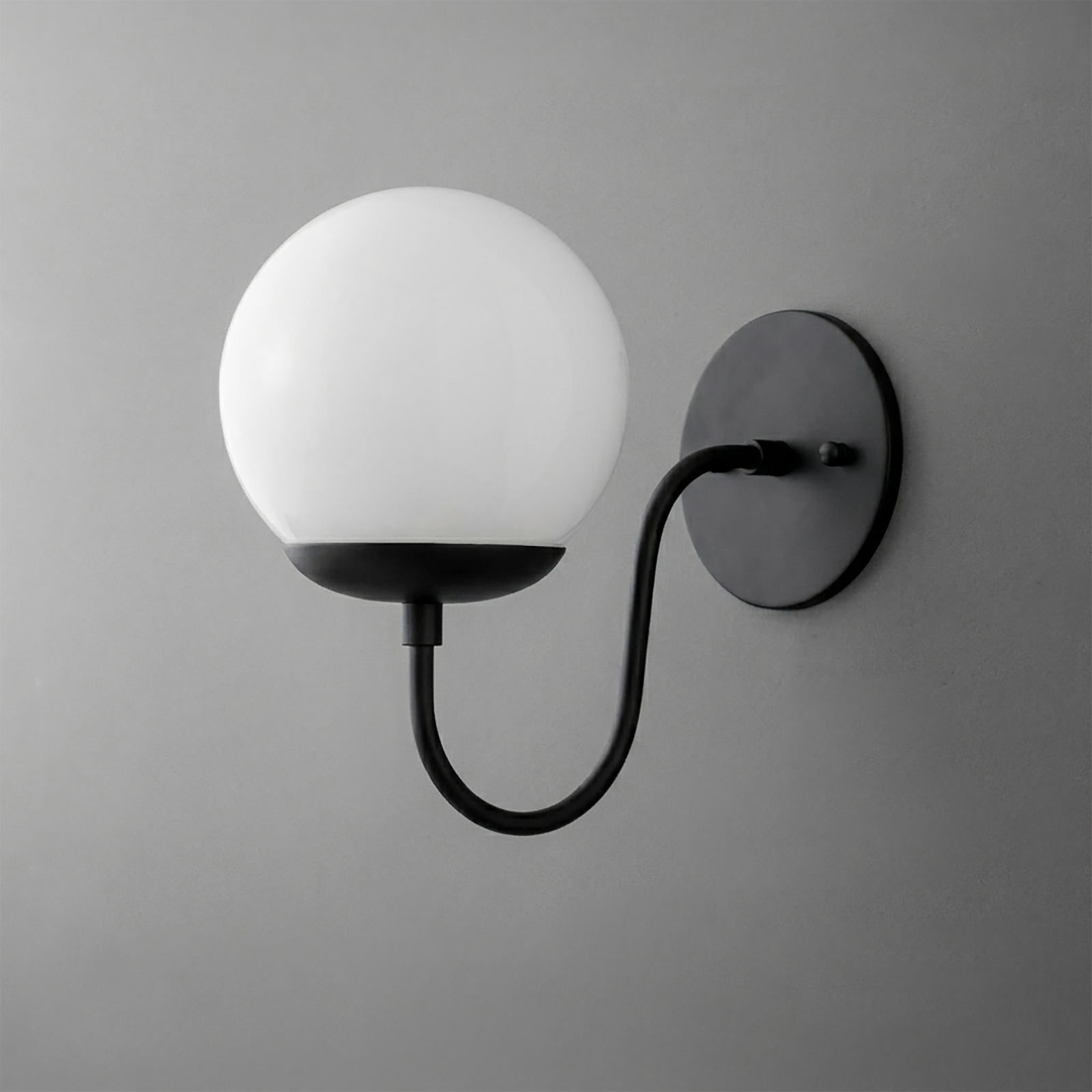 Black metal wall sconce with curved arm and round white glass globe shade. - SCONCE MODEL NO. 3849