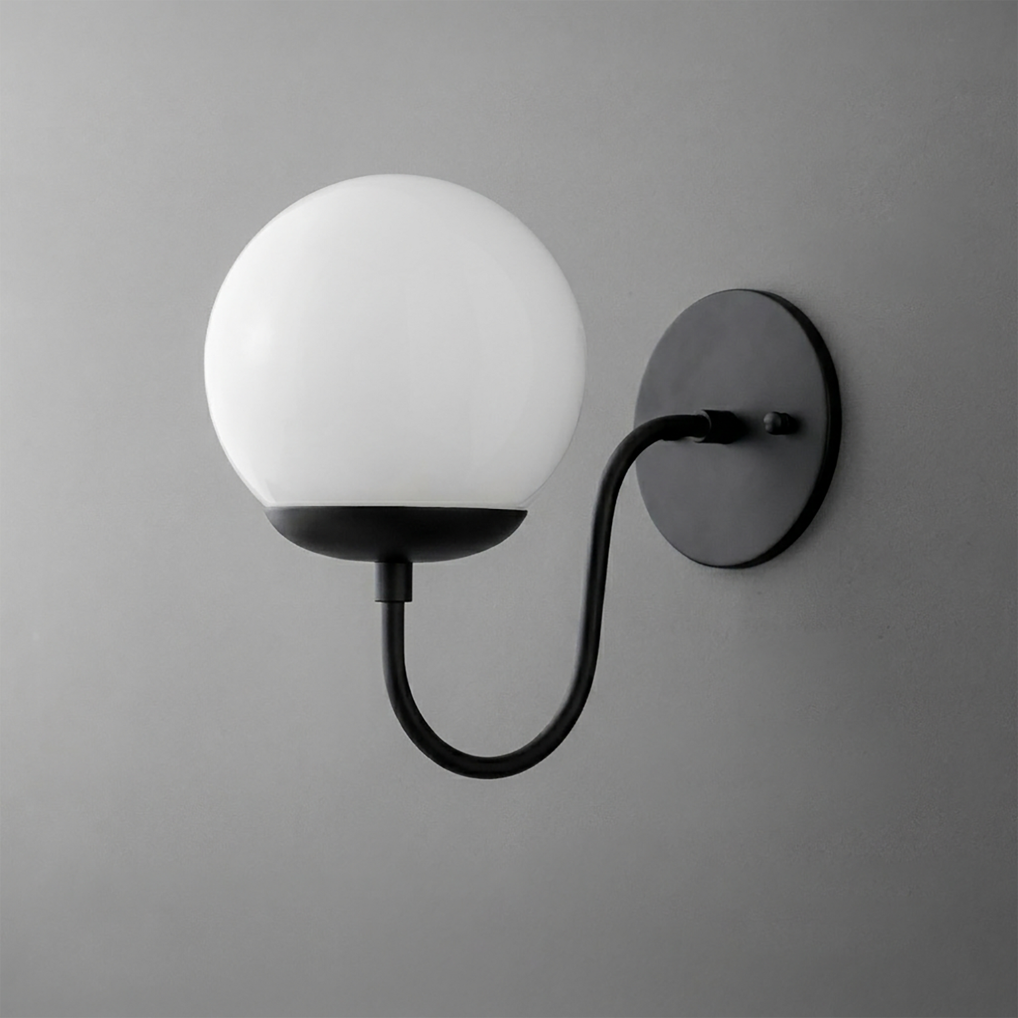 Black metal wall sconce with curved arm and round white glass globe shade. - SCONCE MODEL NO. 3849