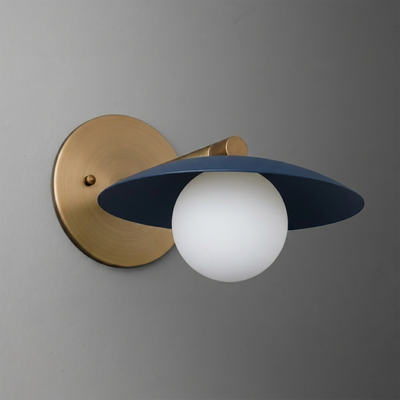 Wall-mounted sconce with brushed brass base and arm, featuring a matte navy blue wide flat shade and a frosted white glass. - SCONCE MODEL NO. 9872