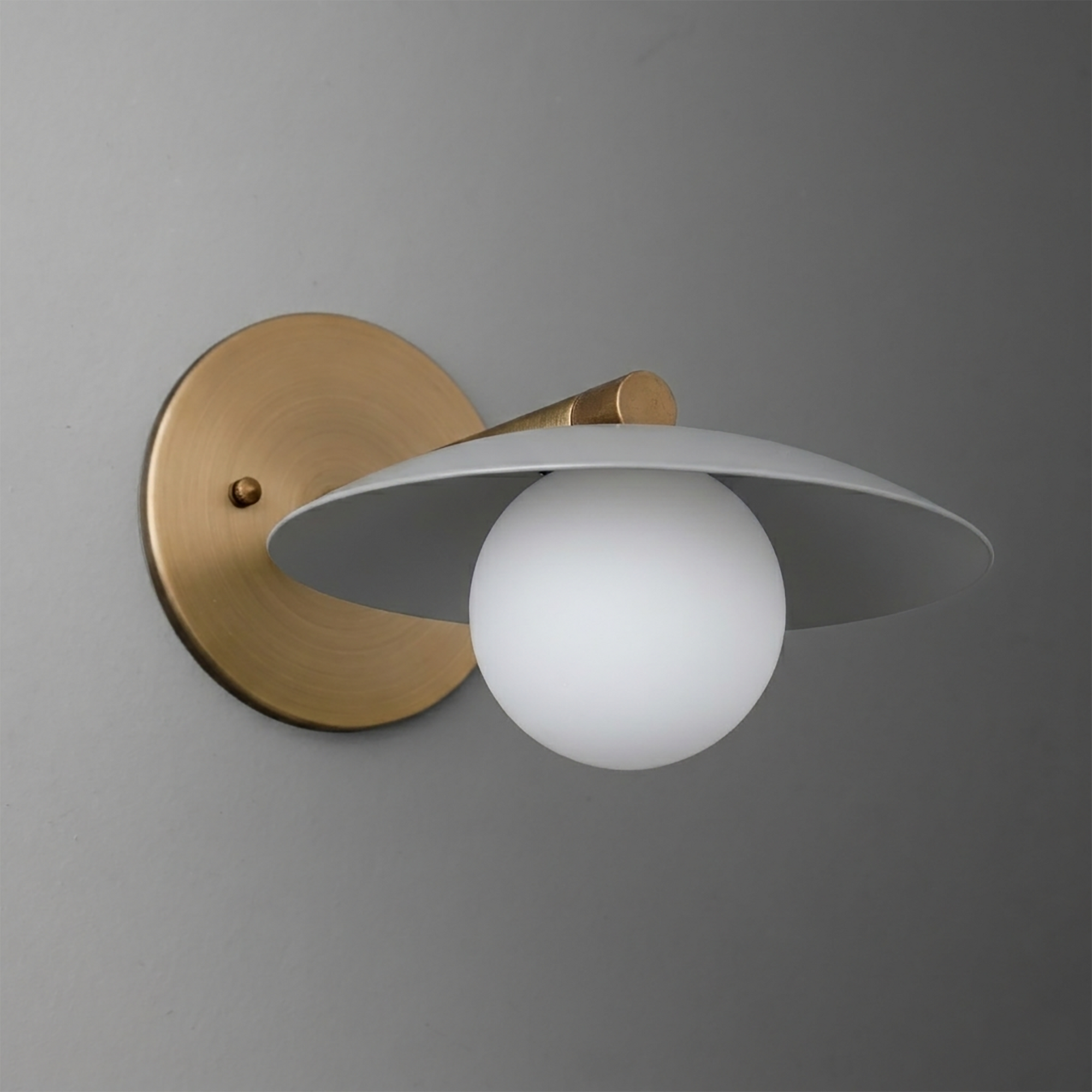 Wall sconce with brushed brass round base and white matte globe shade, minimalist design. - SCONCE MODEL NO. 9872