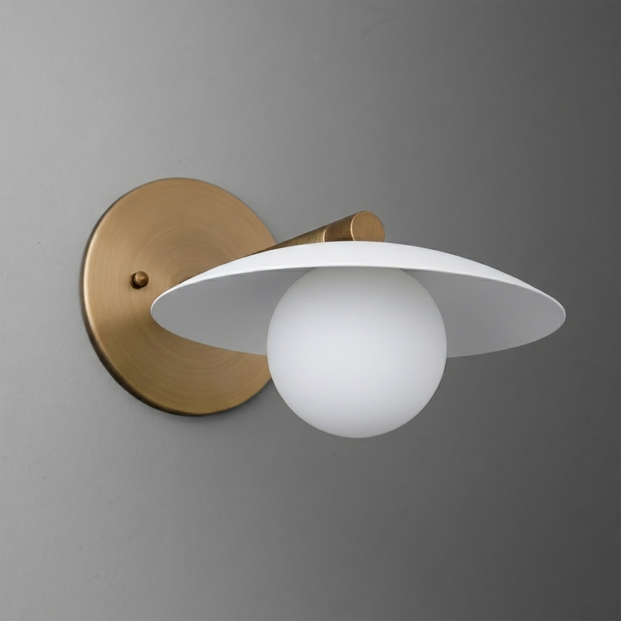 Wall sconce with round brass base, white conical shade, and frosted globe bulb hanging below center. - SCONCE MODEL NO. 9872