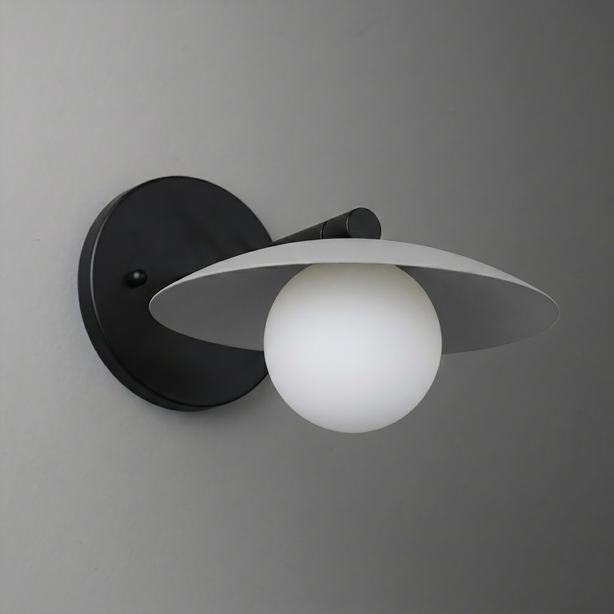 Black metal wall sconce with a matte finish, featuring a round backplate, a thin conical shade, and a frosted white globe. - SCONCE MODEL NO. 9872