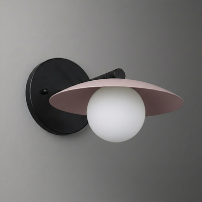 Black metal wall sconce with round backplate, white globe bulb, and wide mauve shade. - SCONCE MODEL NO. 9872