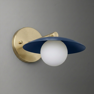 Wall sconce with brushed brass mount and arm, featuring a white globe bulb under a matte navy blue flat shade. - SCONCE MODEL NO. 9872