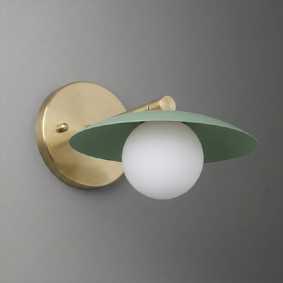 Wall sconce with a round brass base and arm, featuring a matte green wide flat shade and a white globe bulb. - SCONCE MODEL NO. 9872