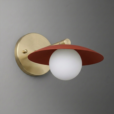 Wall sconce with matte gold circular base, white globe bulb, and flat rust-red shade angled downward. - SCONCE MODEL NO. 9872
