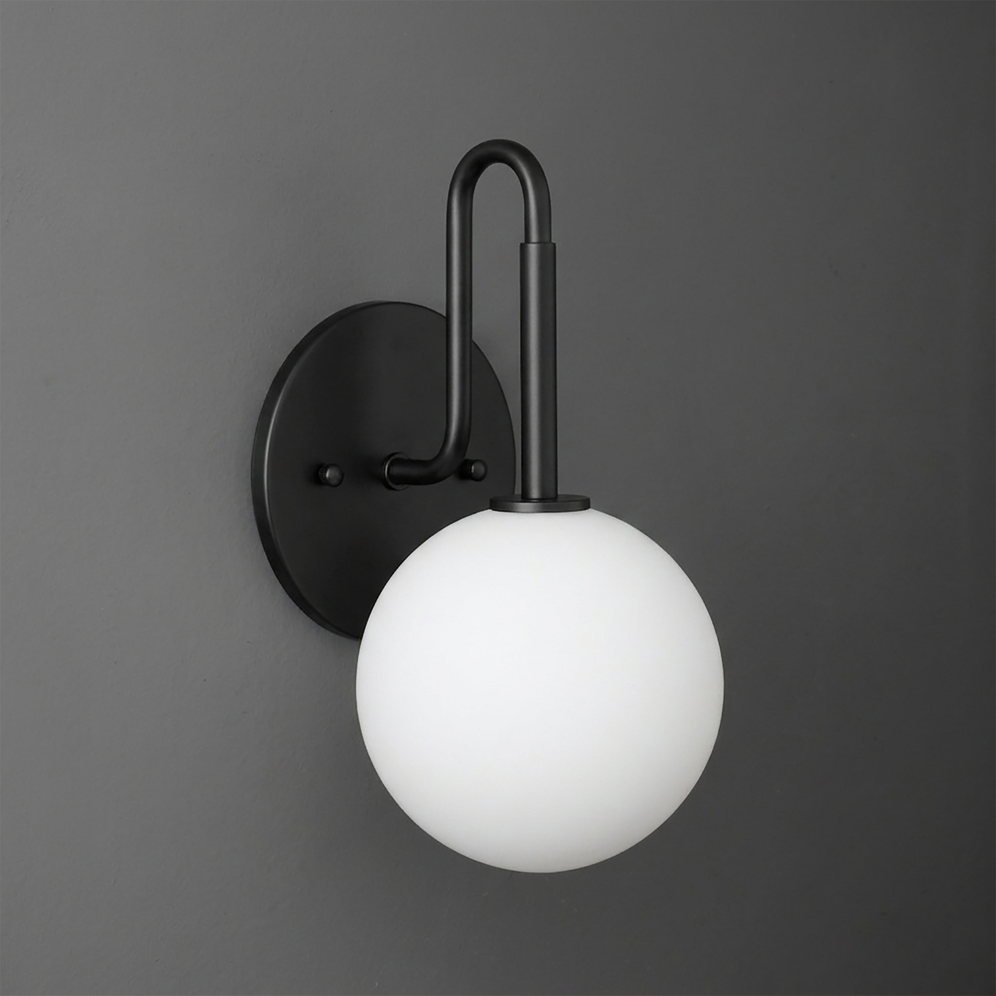 Matte black metal wall sconce with a curved arm and frosted white glass globe shade. - SCONCE MODEL NO. 9106
