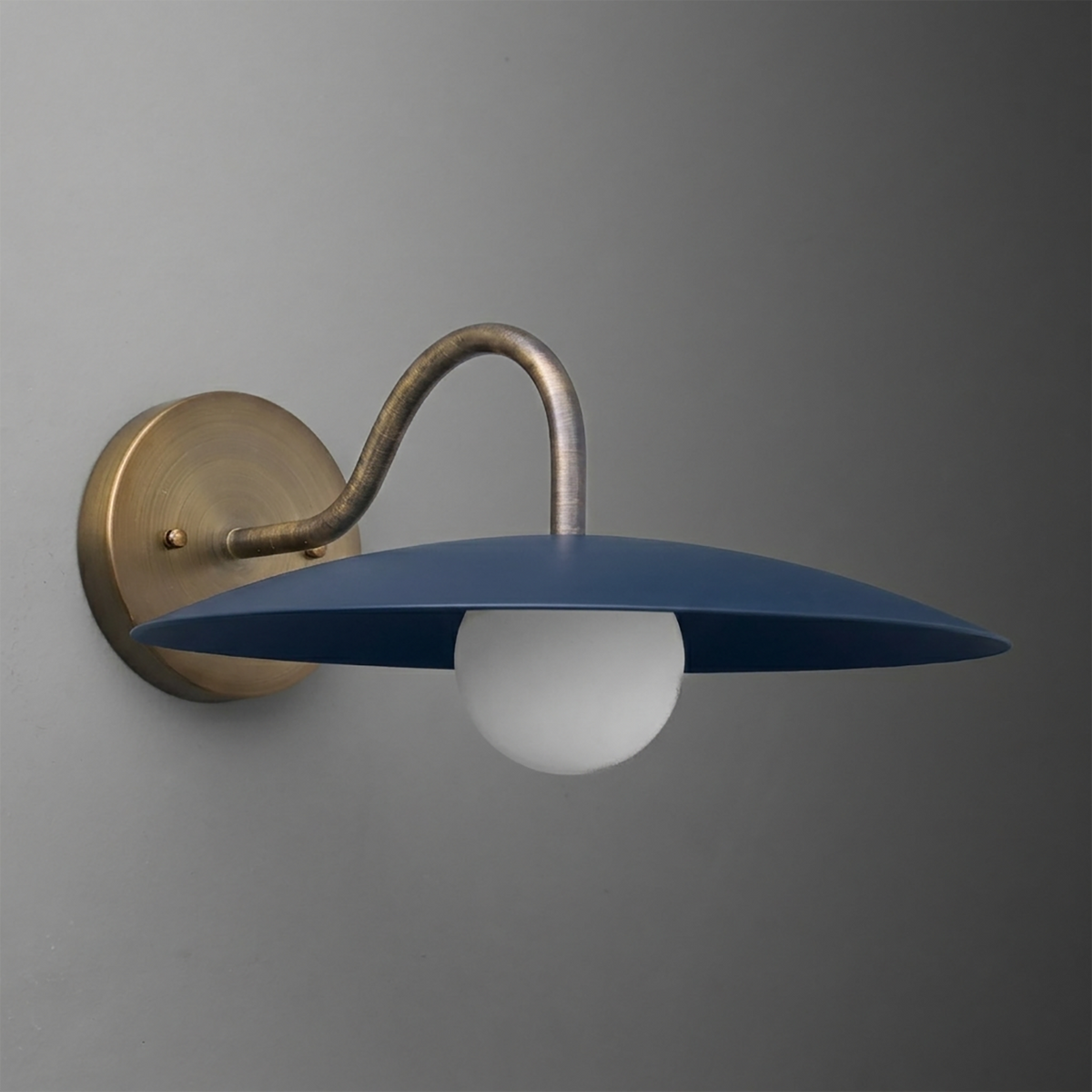 Wall-mounted sconce with curved brass arm and flat, wide matte blue metal shade over a white globe bulb. - SCONCE MODEL NO. 2162