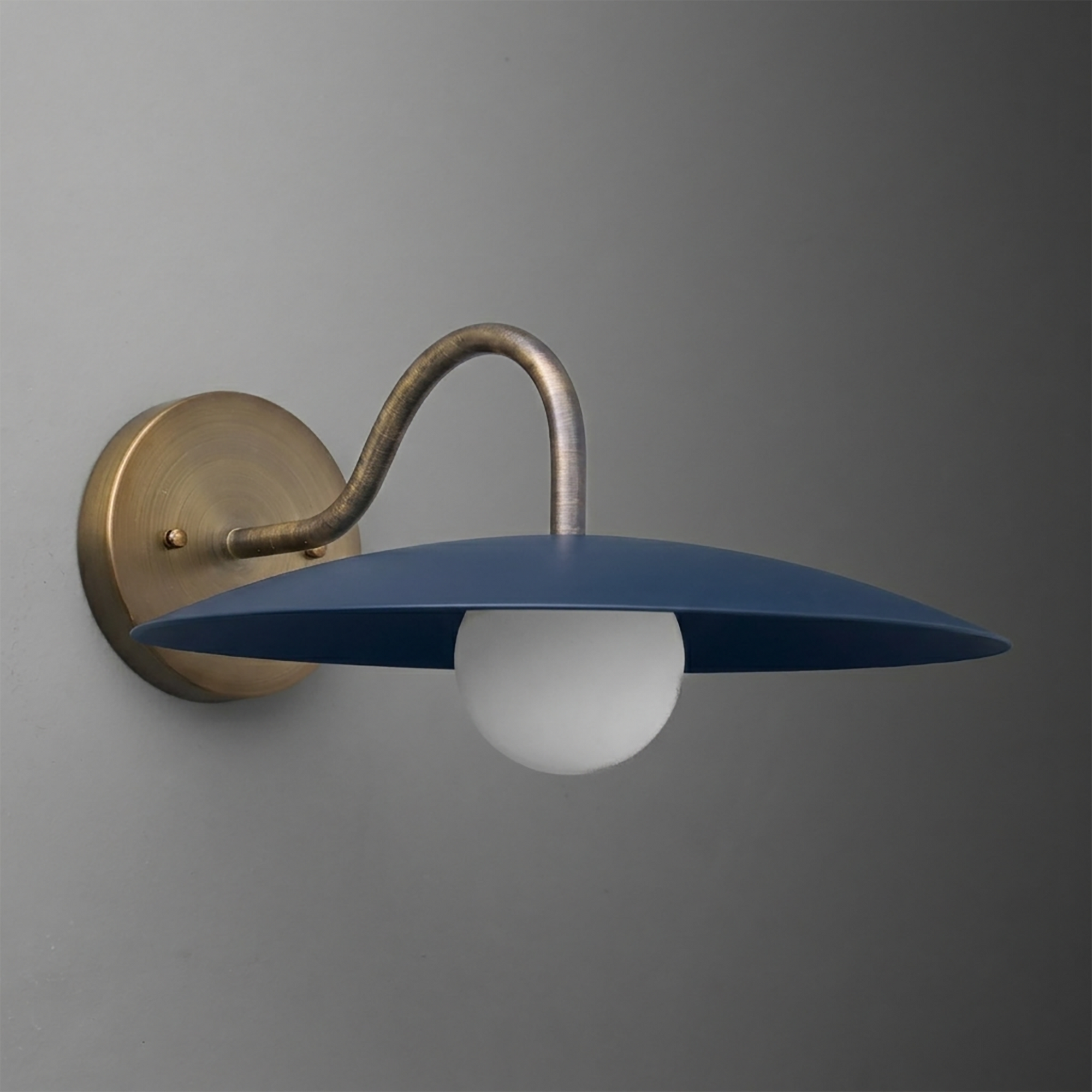 Wall-mounted sconce with curved brass arm and flat, wide matte blue metal shade over a white globe bulb. - SCONCE MODEL NO. 2162