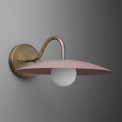 Wall-mounted sconce with aged brass curved arm and round base, featuring a matte pink wide, flat shade and a single exposed. - SCONCE MODEL NO. 2162