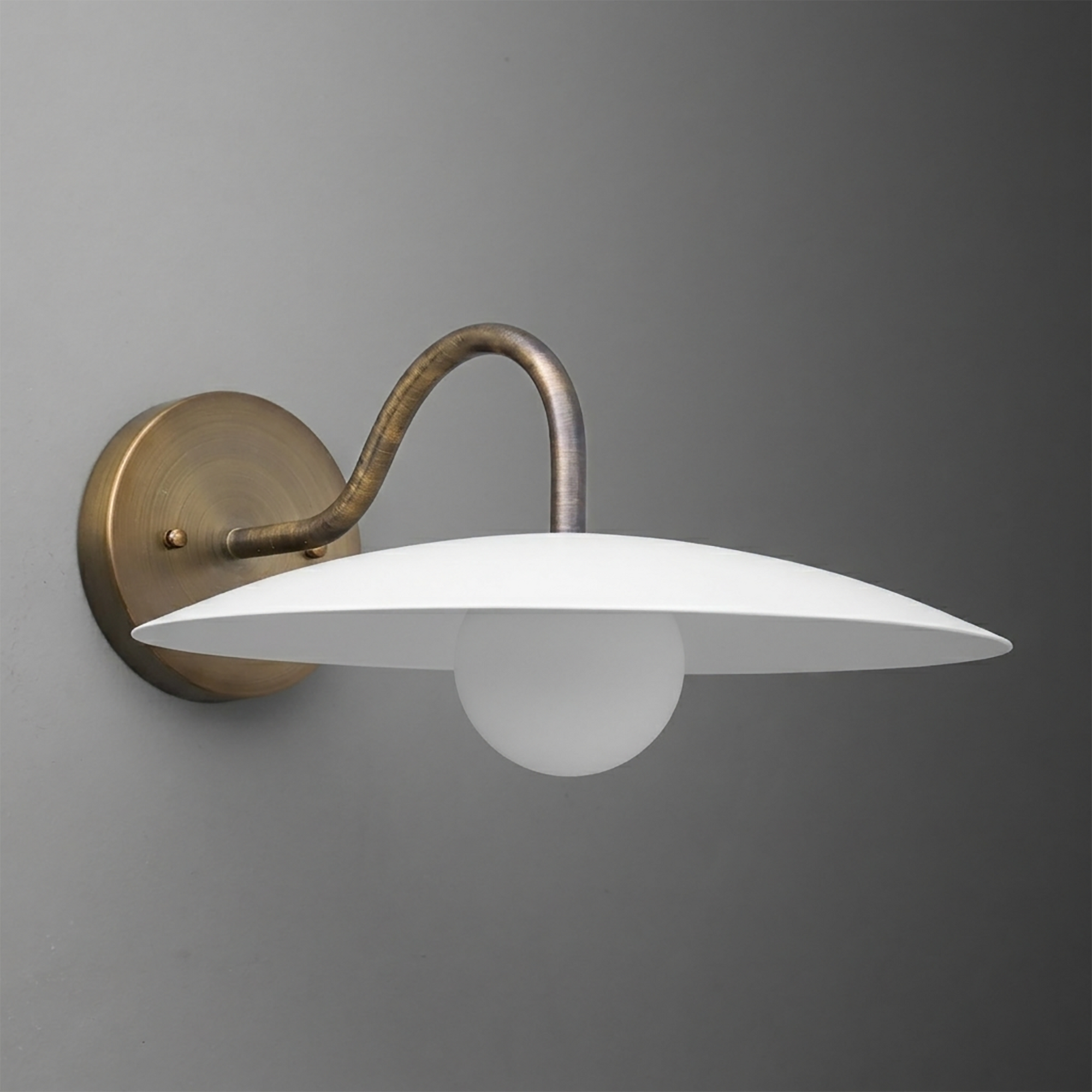 Antique brass single-bulb wall sconce with curved arm and flat white metal shade. - SCONCE MODEL NO. 2162