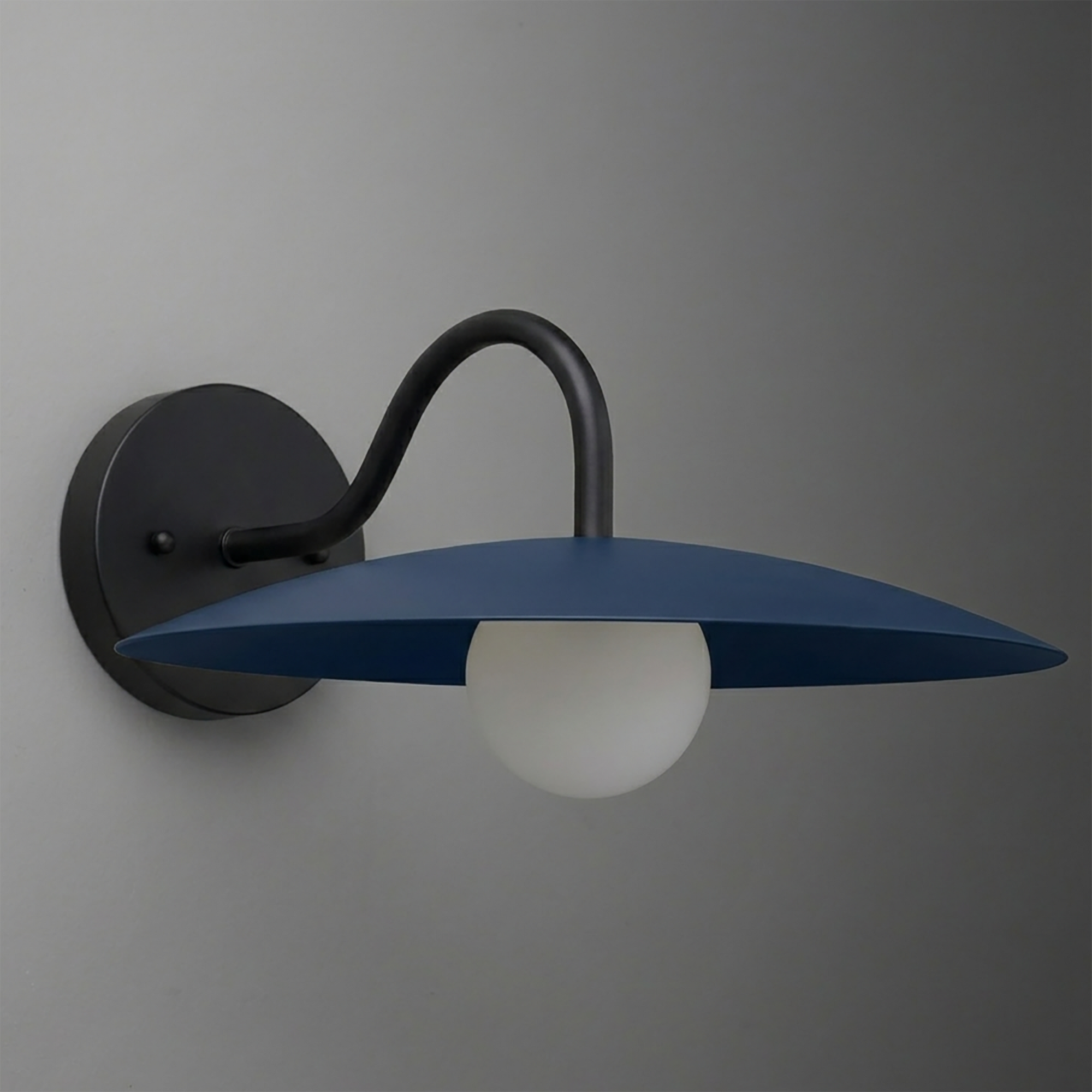 Black metal wall sconce with curved arm and flat blue conical shade over frosted white globe bulb. - SCONCE MODEL NO. 2162
