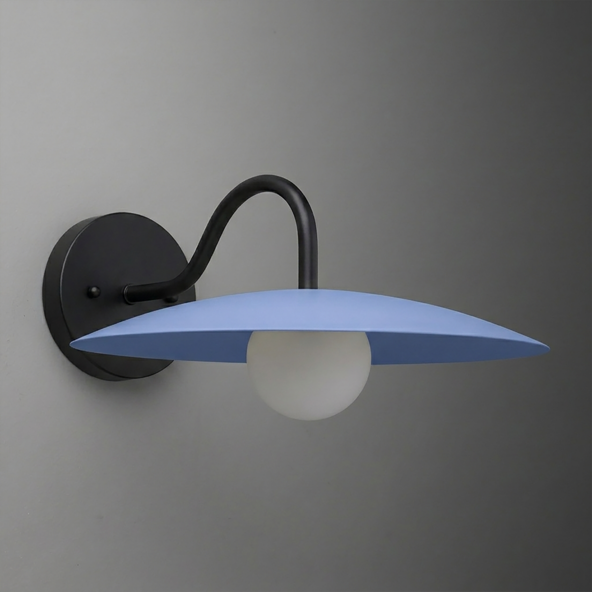 Matte black metal wall sconce with curved arm supporting flat, wide blue shade and round white bulb. - SCONCE MODEL NO. 2162