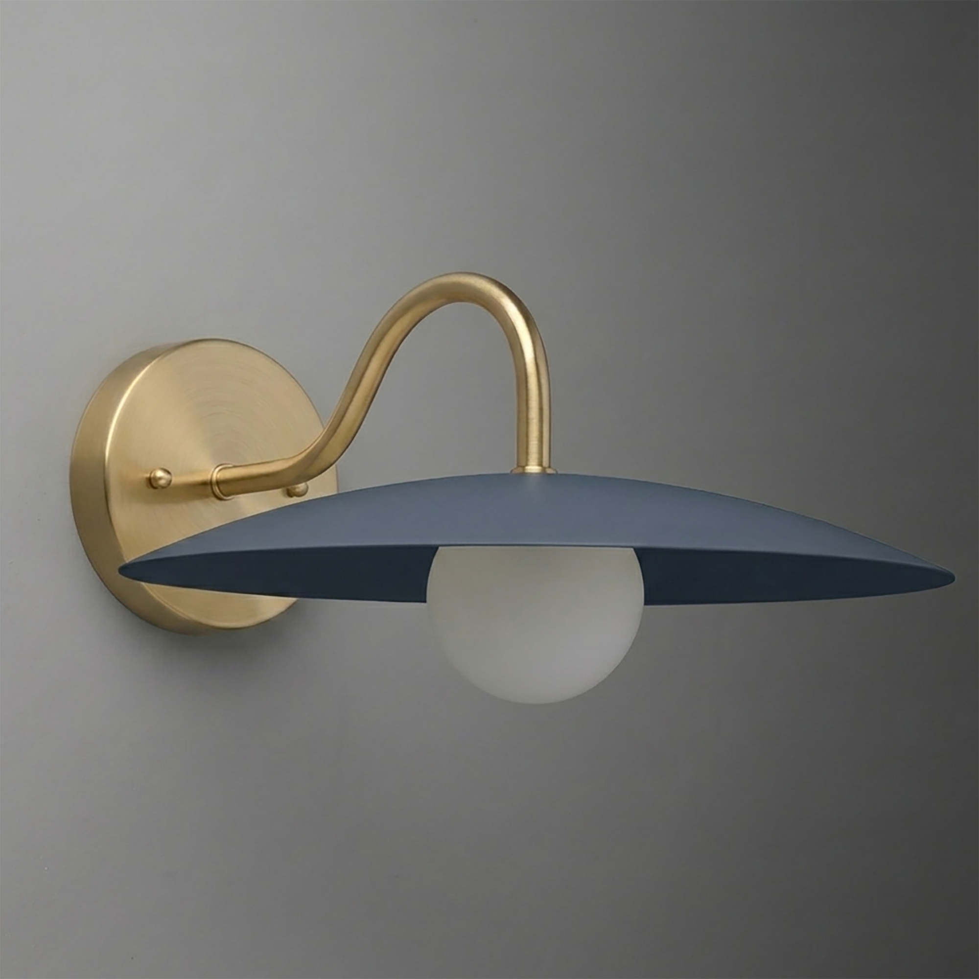 Wall-mounted sconce with matte gold curved arm, round base, and flat navy blue shade over white bulb. - SCONCE MODEL NO. 2162