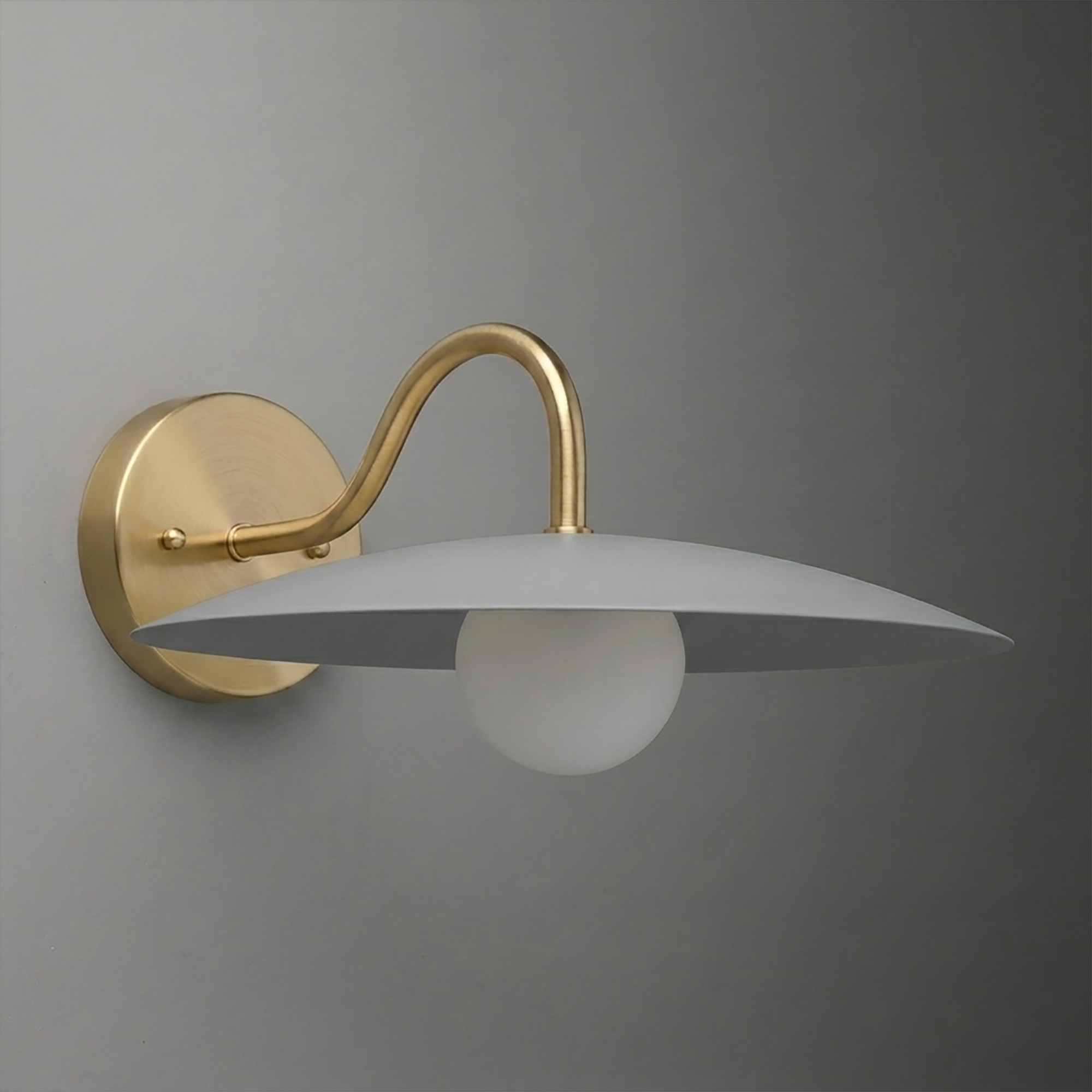Brushed brass wall sconce with curved arm and wide, flat silver metal shade over round white bulb. - SCONCE MODEL NO. 2162