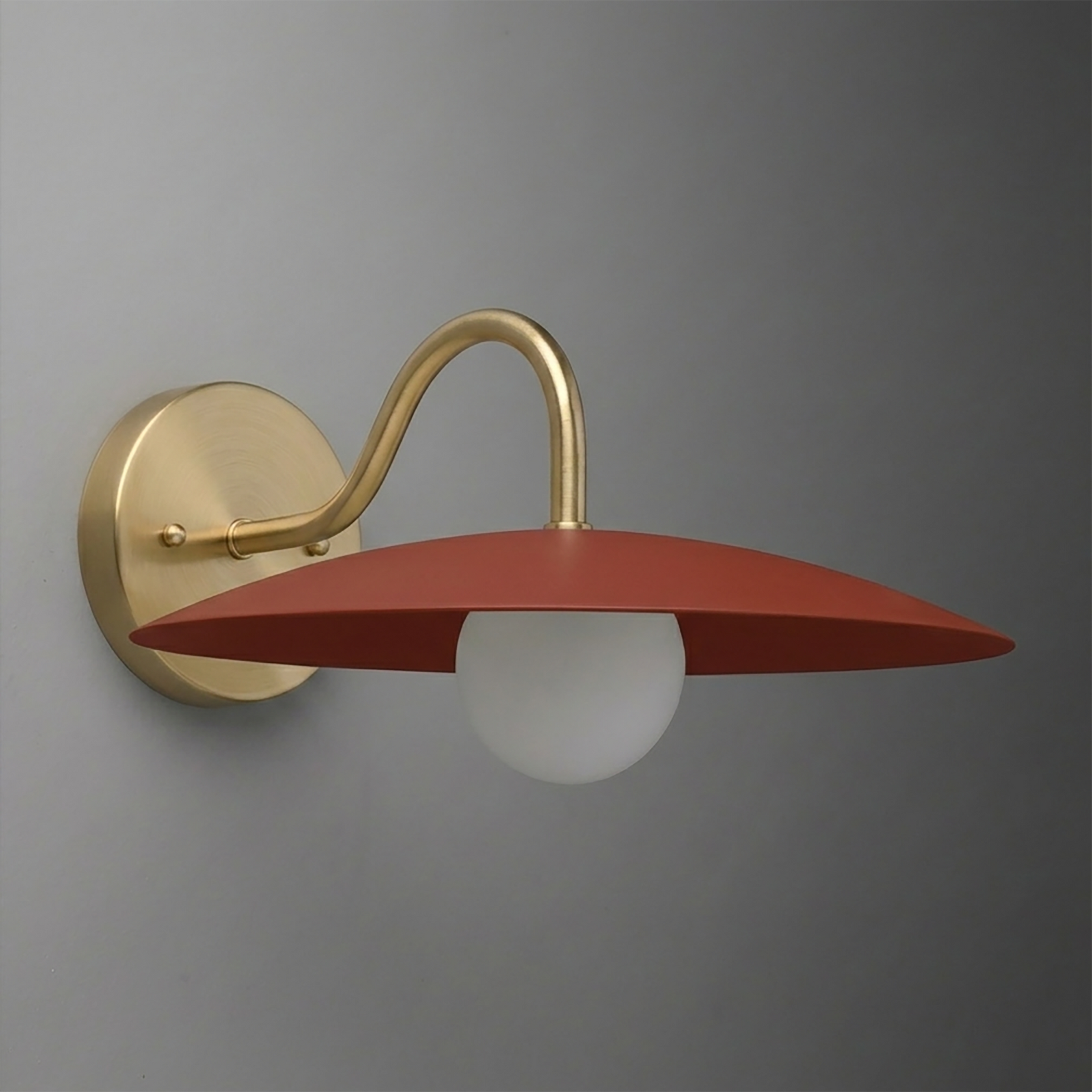 Wall sconce with matte gold curved arm and flat, wide rust-red metal shade over white bulb. - SCONCE MODEL NO. 2162