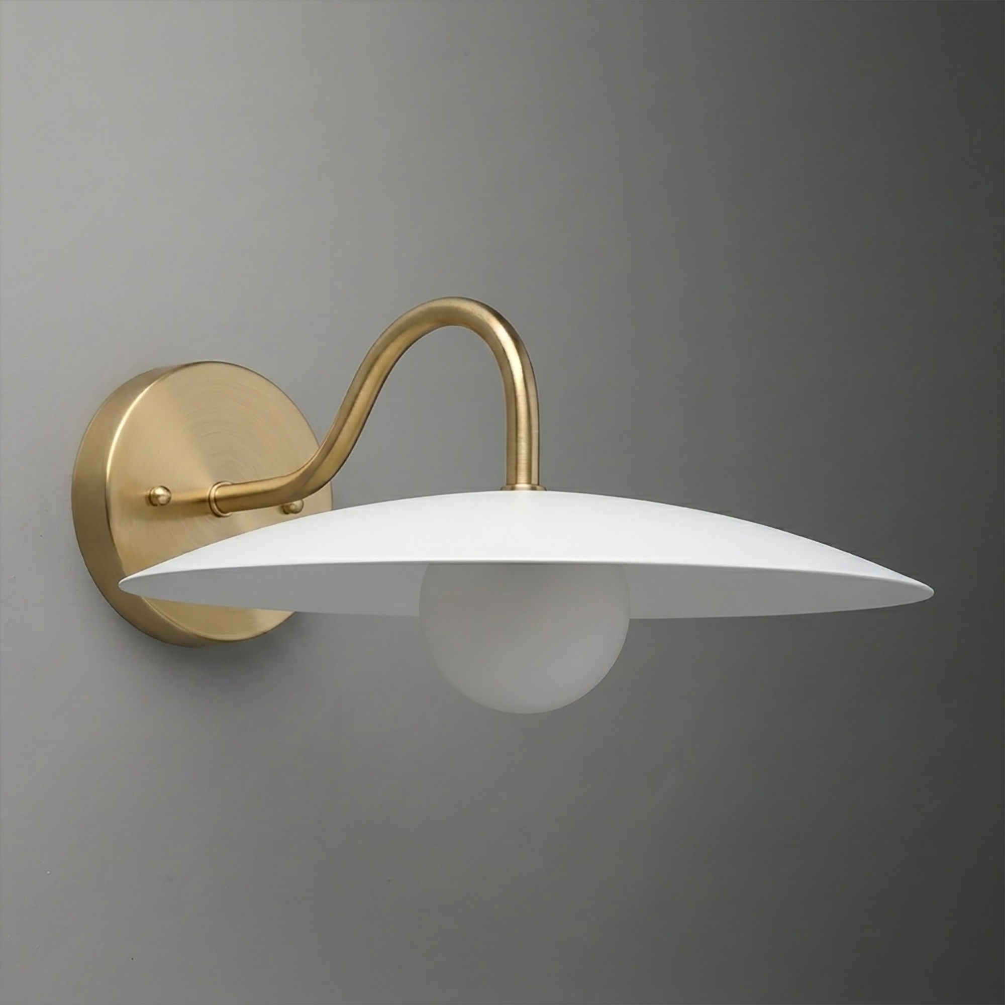 Wall sconce with brushed brass curved arm and round mount, white saucer-shaped shade, single exposed bulb beneath. - SCONCE MODEL NO. 2162